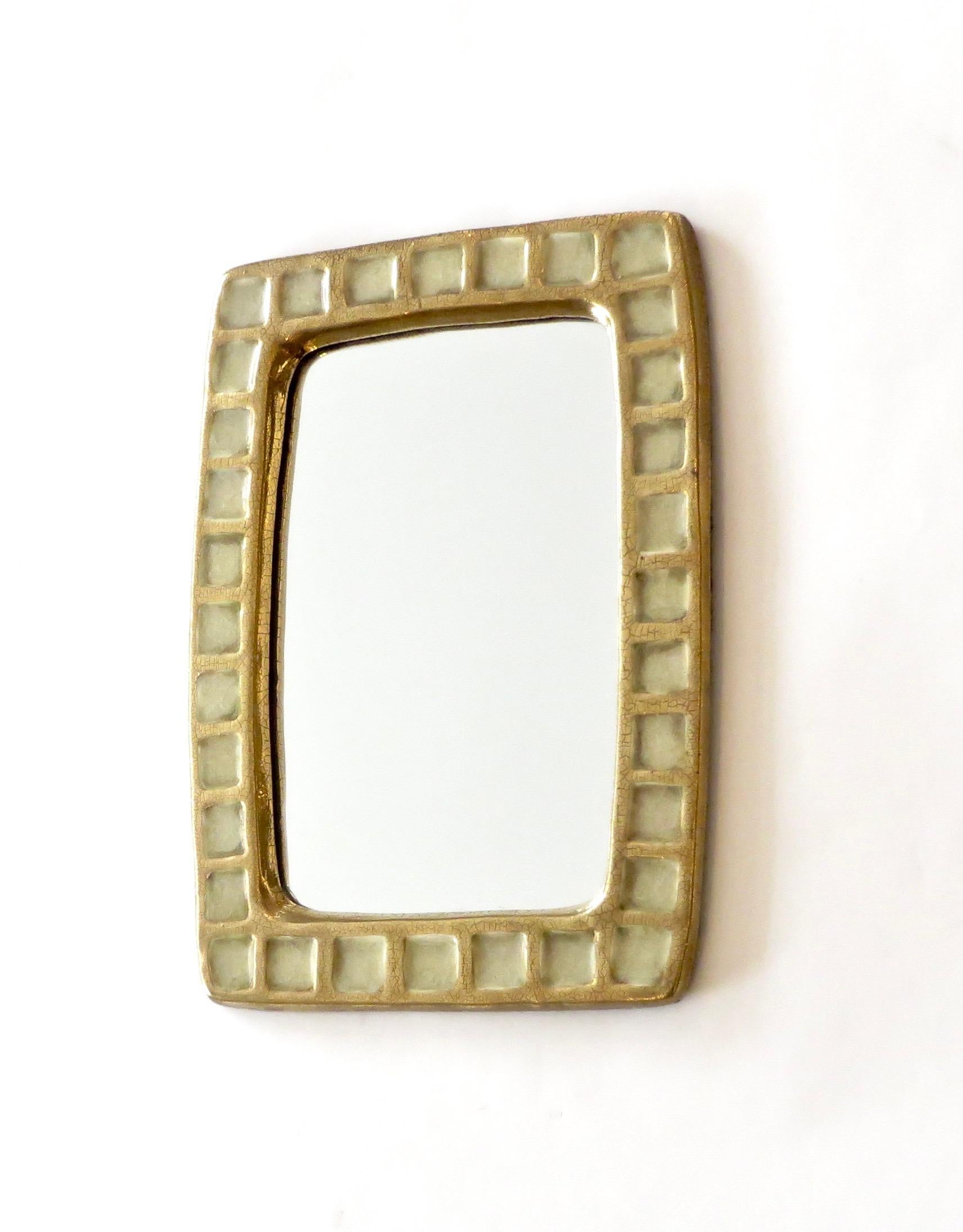 A mirror created by Mithé Espelt, circa 1960, in France. The mirror is composed of tiled fused glass within a gold crackle glazed ceramic frame.
 Very fine original condition.
 A similar mirror is pictured on p 111 in the book Mithe Espelt, The