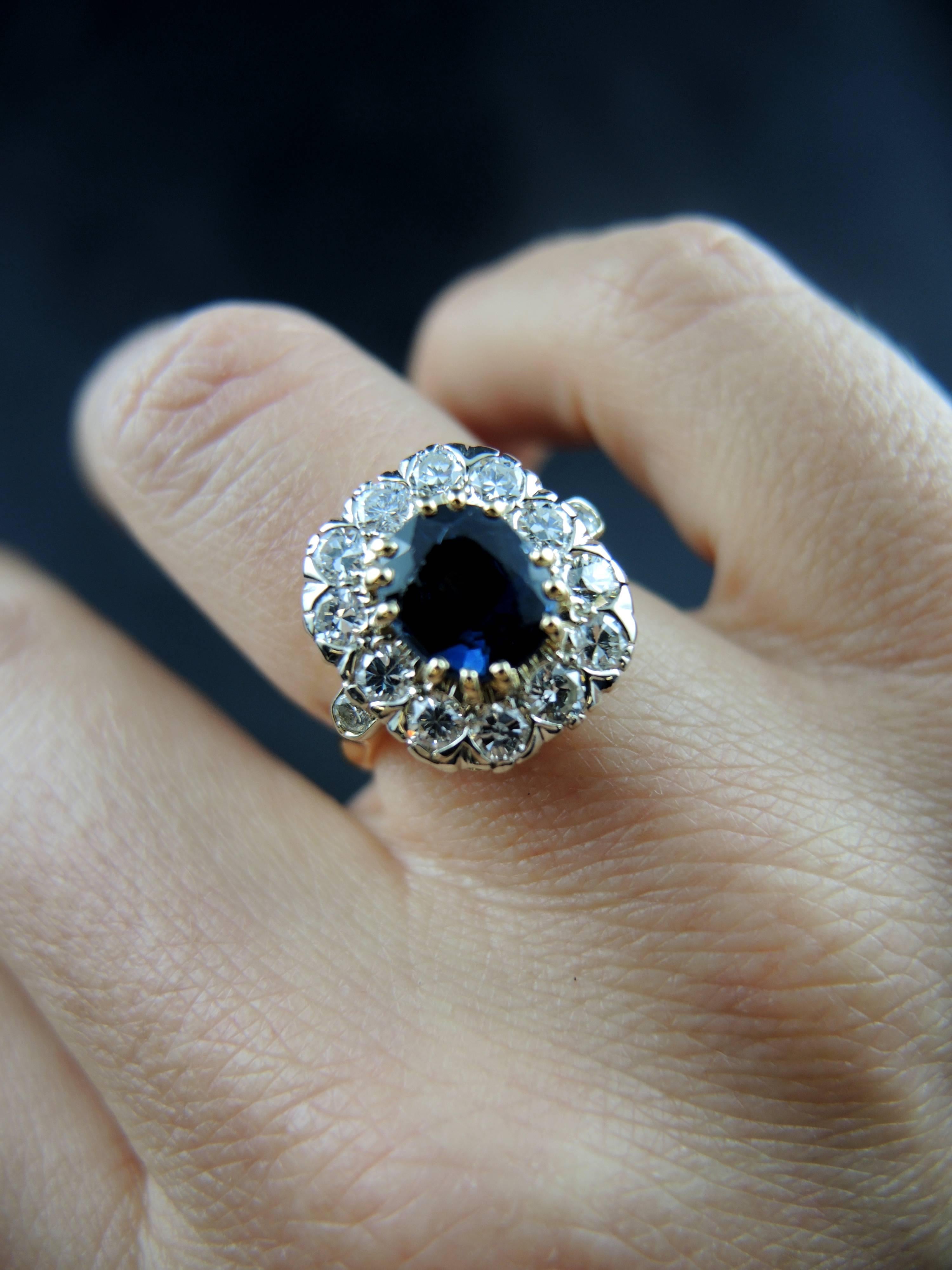 Yellow and white gold cluster ring (quality mark: head of eagle) set with a central oval sapphire, weight estimated around 2.00 Cts, surrounded with modern brillant cut diamonds, which total weight is estimated around 0,75 Ct.

French work, circa