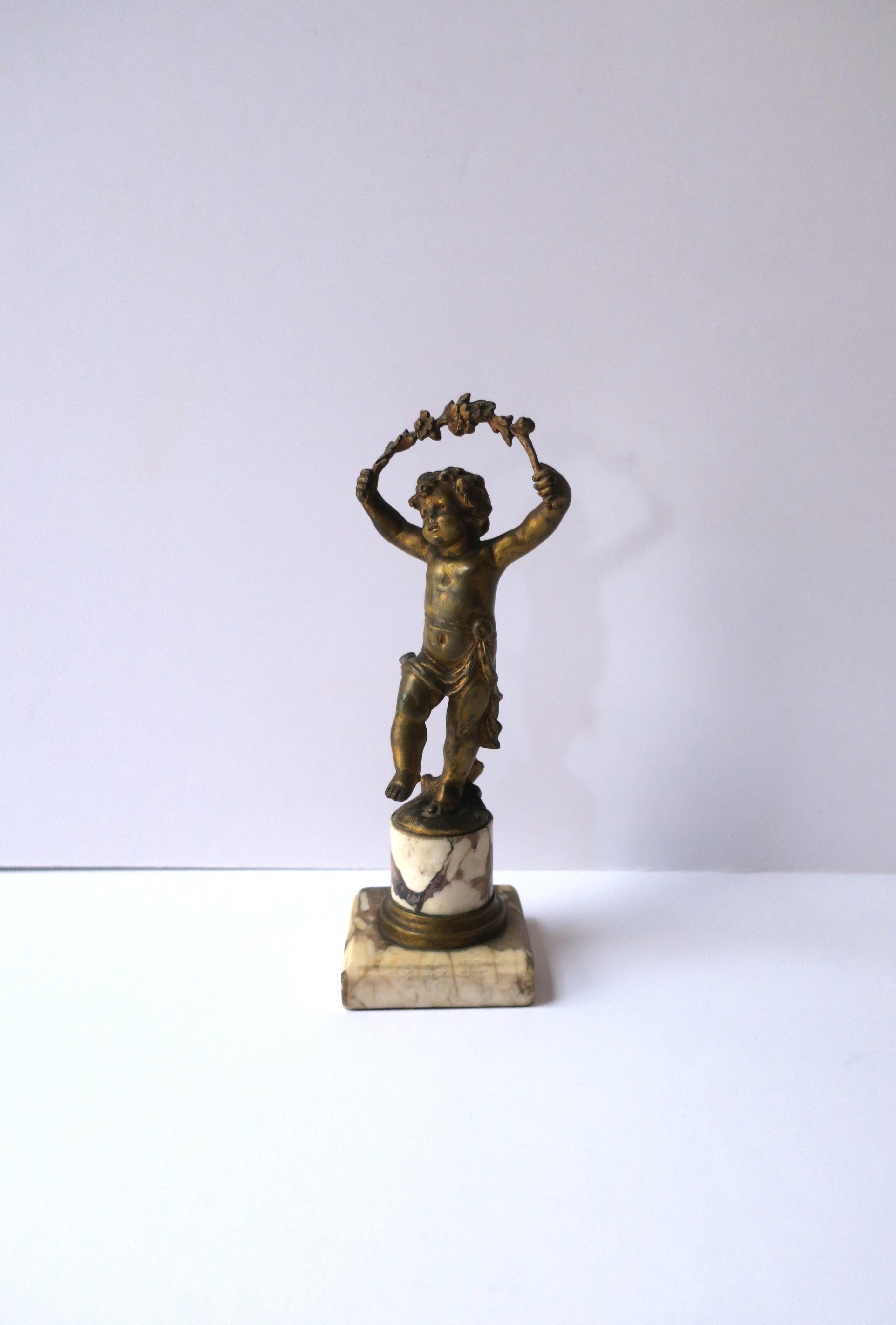 An antique French gold gilt bronze male 'putti' figure sculpture atop a marble column, Belle Epoque, circa late-19th century, France. A substantial patinated gold gilt bronze male 'putti' mounted on a marble column and base. A great decorative