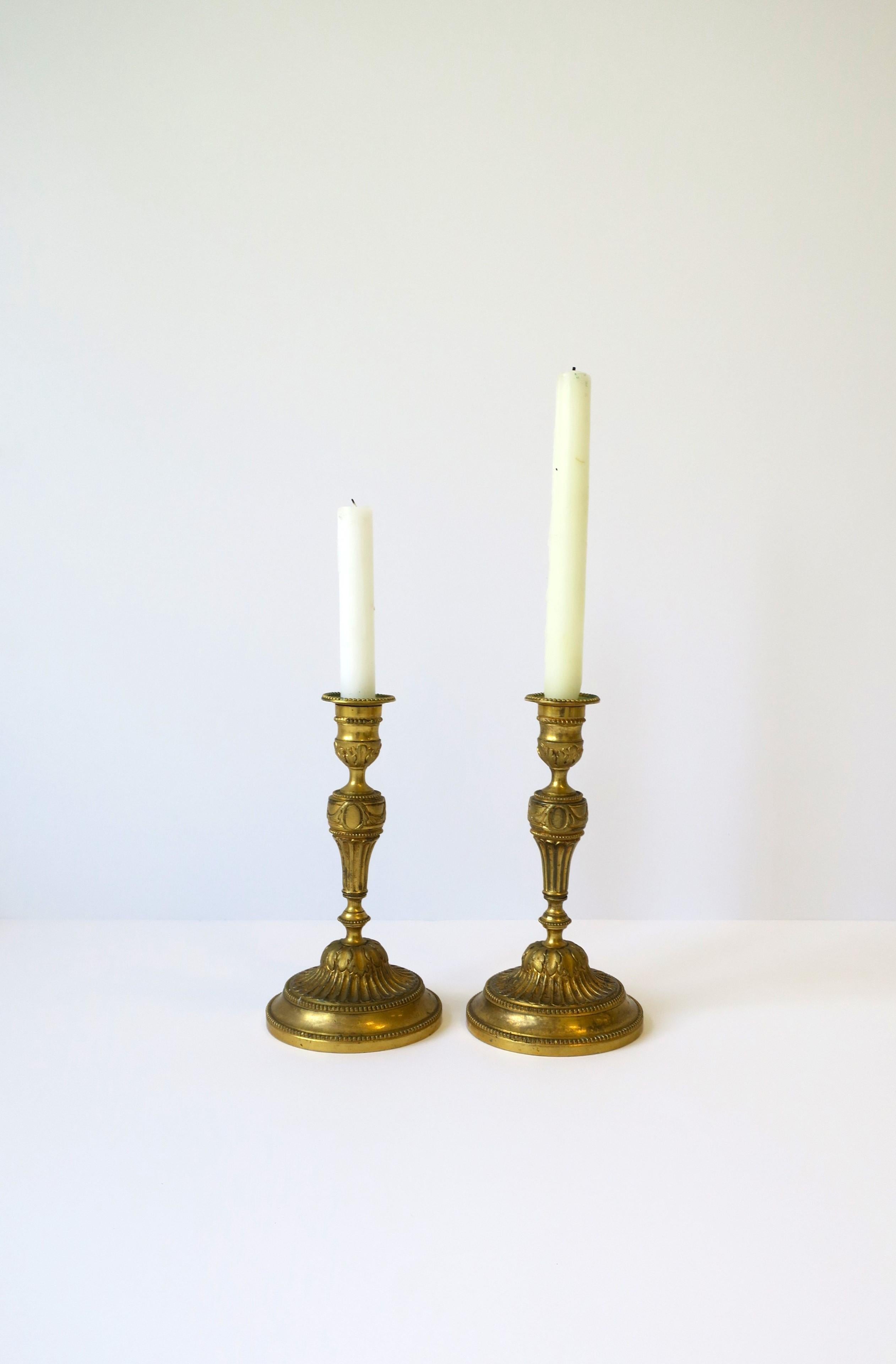 A substantial pair of French gold gilt bronze candlestick holders in the Neoclassical style, circa mid to late-19th century, France. A raised design relief includes beading and acanthus leaves and fluted base. 

Dimensions: 8.13