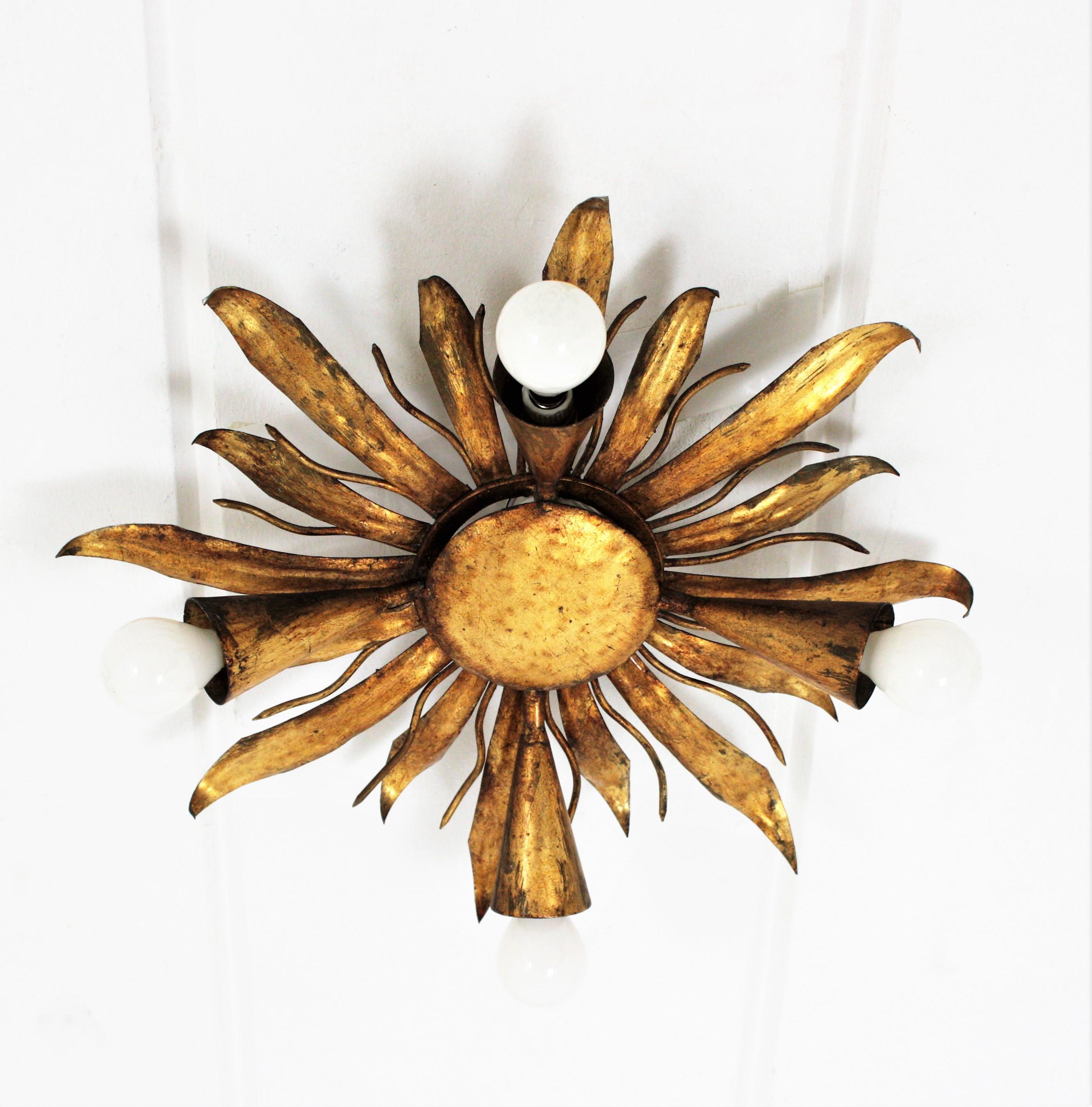 French Gold Gilt Iron Sunburst Flush Mount or Light Fixture, 1940s
French modern neoclassical gilt iron leafed sunburst flush mount or light fixture from the late Art Deco period, France, 1940s.
This sunburst or flower burst light fixture is highly