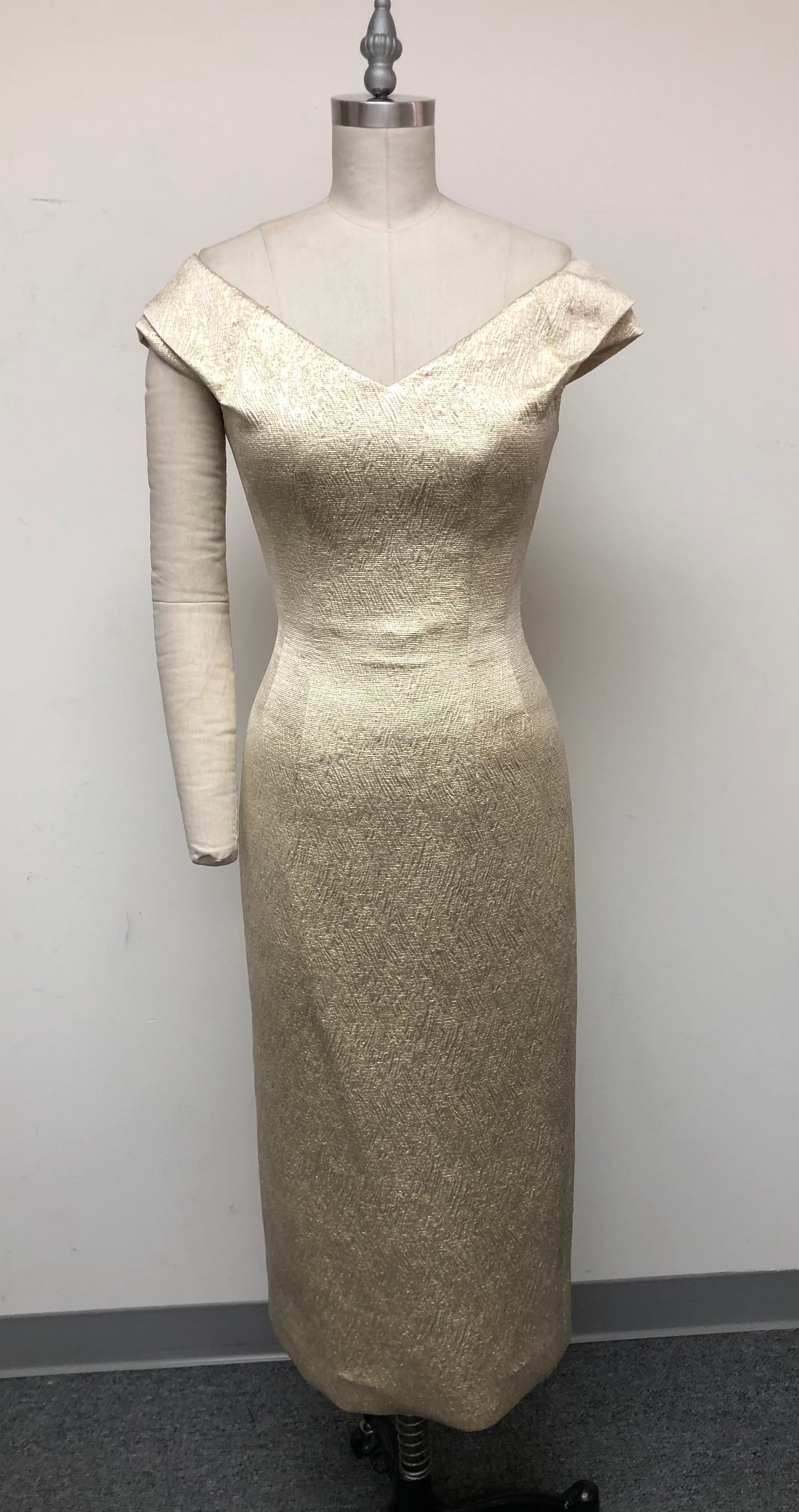 Woven gold French brocade portrait collar dress with v neck and internal bustier—your go-to for parties and weddings. Fits securely around the shoulders with a tiny cap sleeve. The elegant French textile with its delicate woven texture knows all
