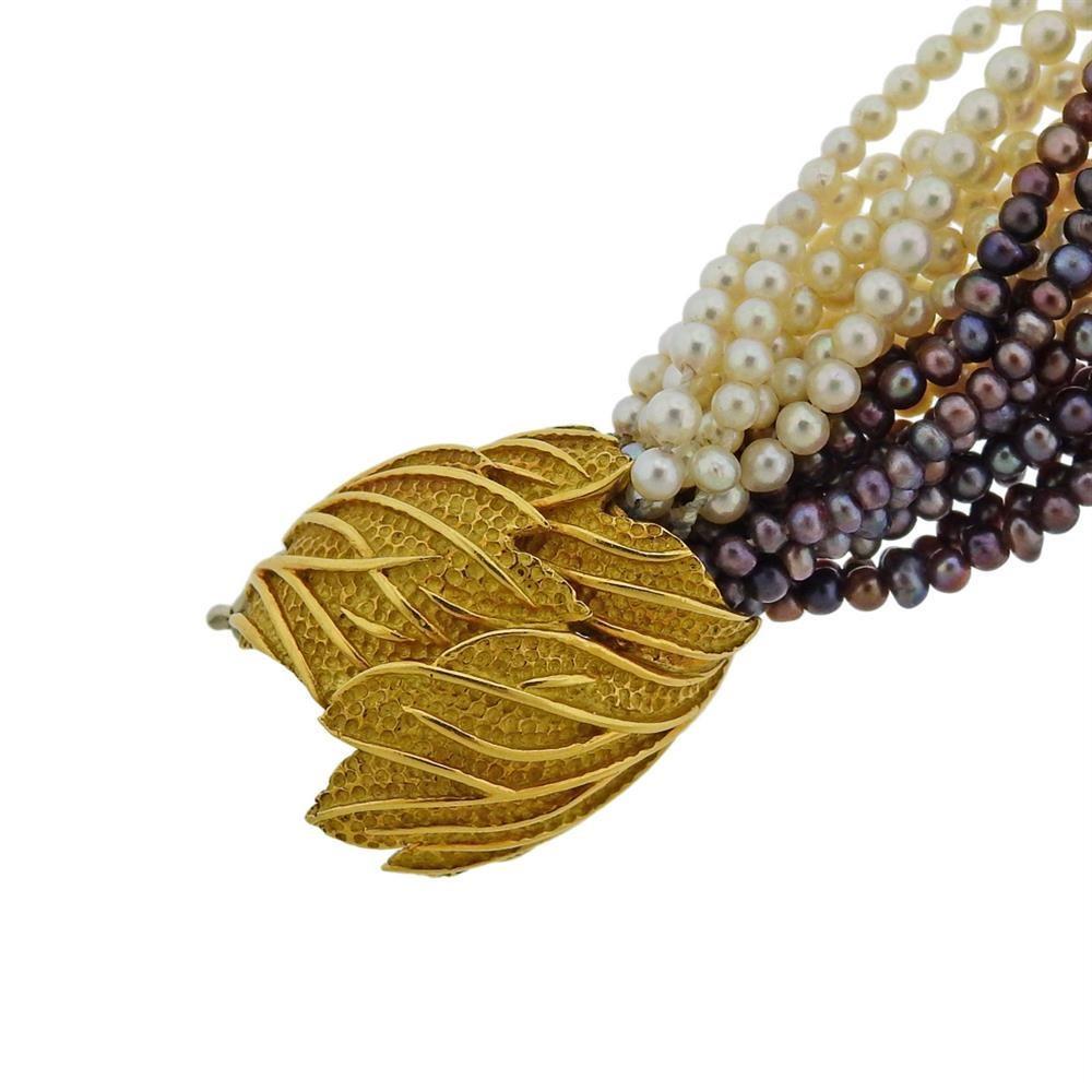 French made 18k gold bracelet, clasp decorated with leaf design, bracelet is constructed of 20 strands of multi color pearls (approx. 2.-3mm). Marked with French eagle mar on the clasp. Bracelet is 59.1 grams.