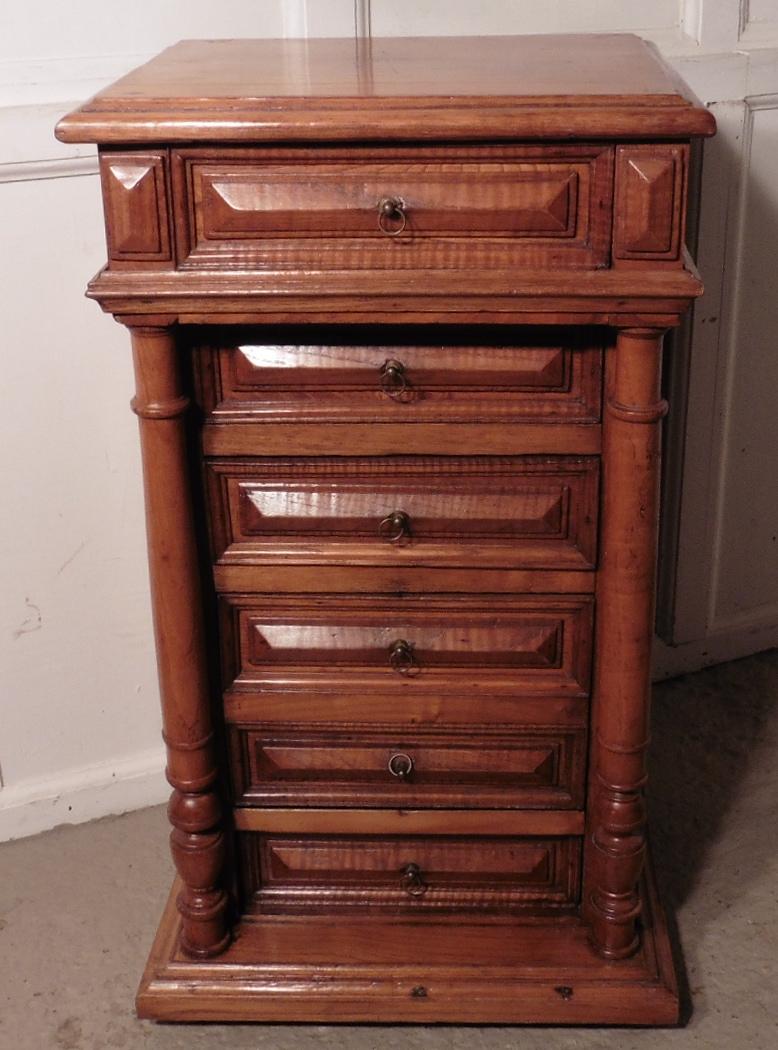 French golden oak bedside cabinet or night table.

 This piece is a very attractive piece made in Golden Oak and Fruitwood, it appears to have 6 drawers to the front, but 2 of the drawer fronts are in fact a fall front cupboard, the cabinet stands