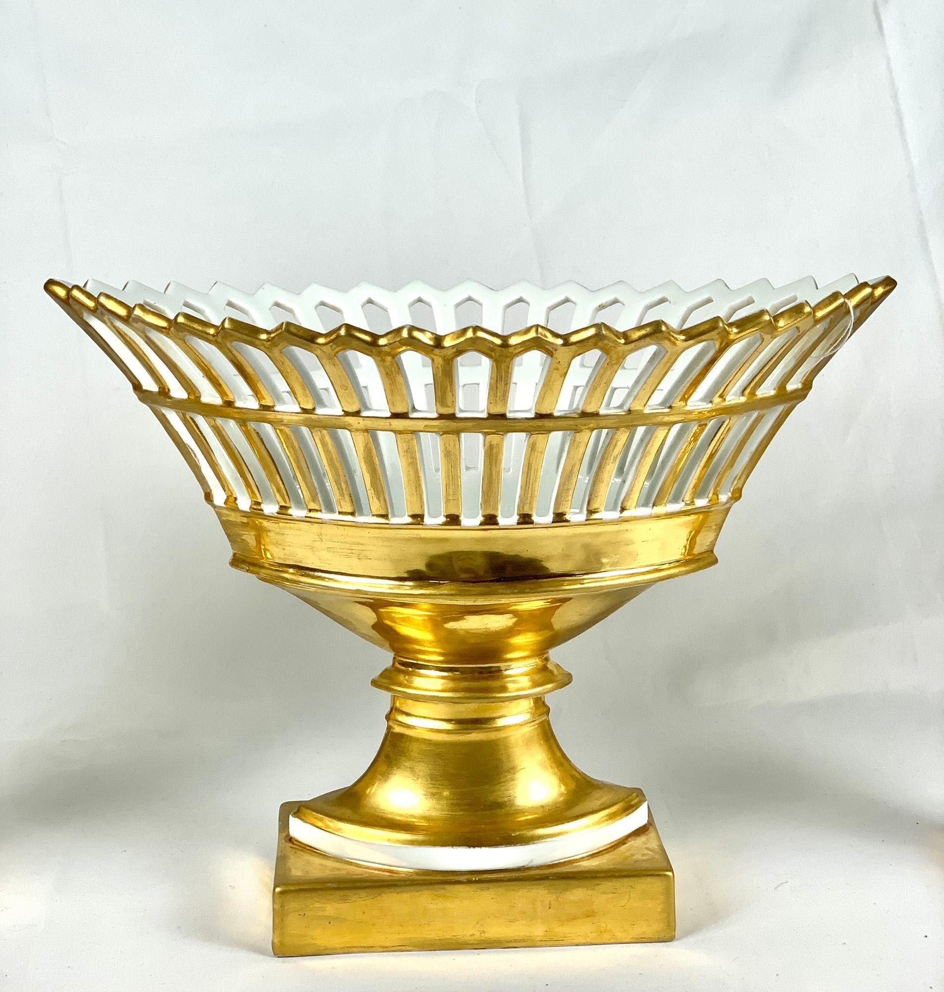This elegant Paris Porcelain pierced basket is oval shaped, with lavishly gilded latticework.
The Empire style is timeless, and the latticework of the baskets lends delicacy and light to the design.
The white line across the top of the base