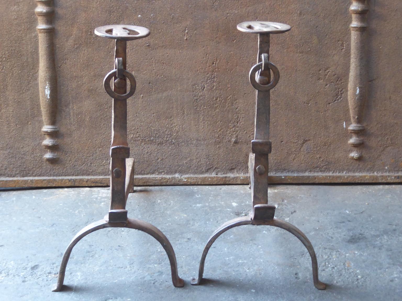 17th-18th century French andirons made of wrought iron. The style of the andirons is Gothic. The andirons have spit hooks to grill food. They are in a good condition.