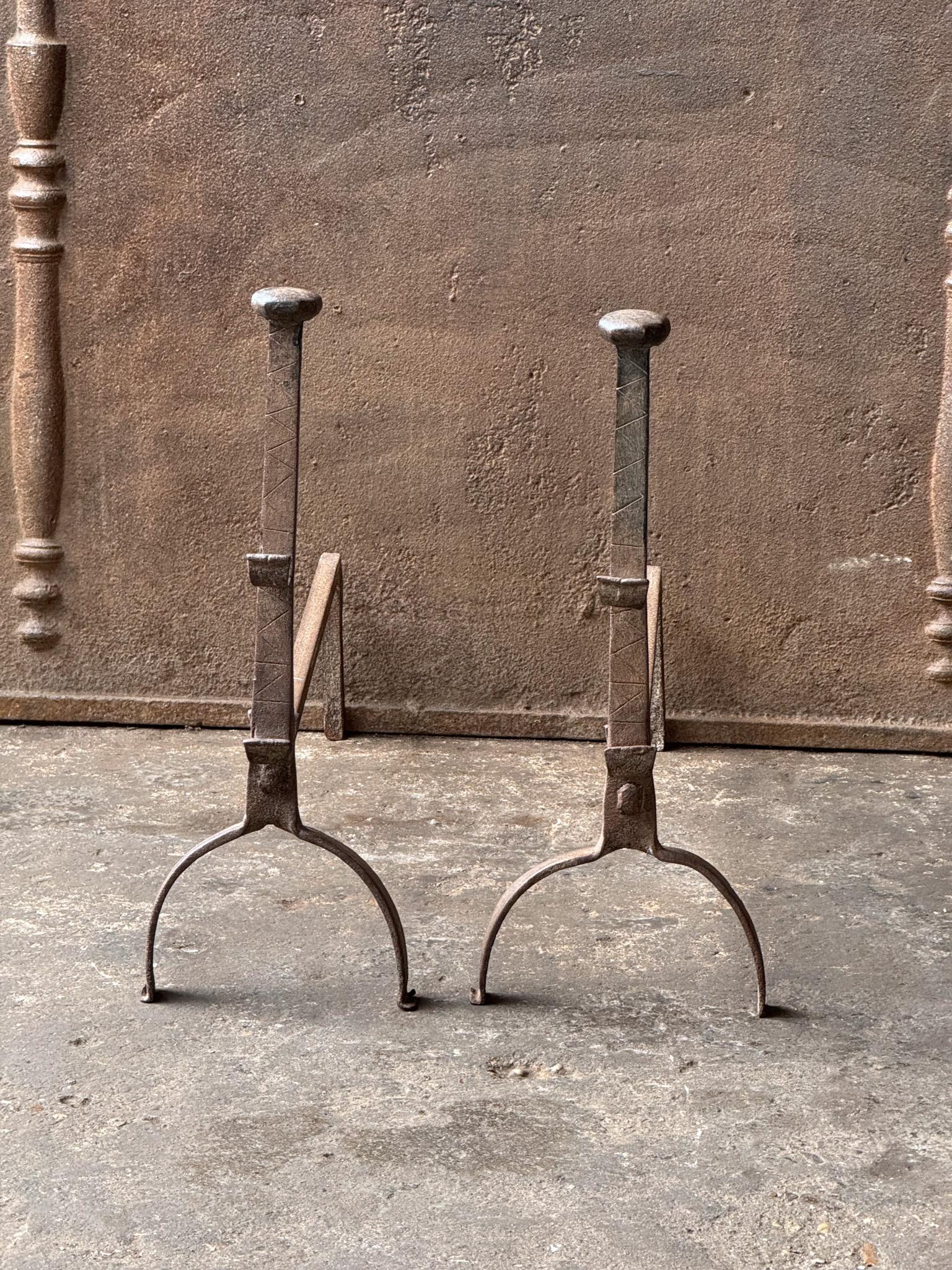 17th century French andirons made of wrought iron. The andirons have spit hooks to grill food. They are in good condition.