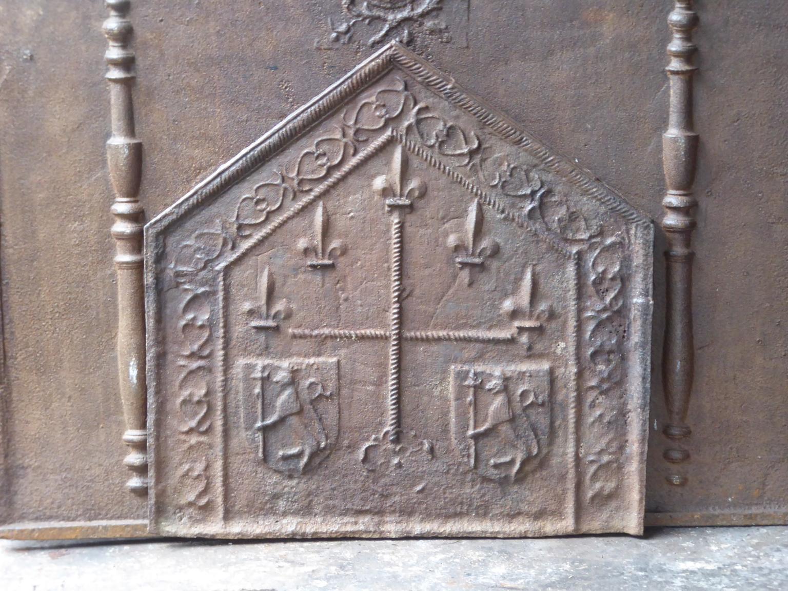 16th century French Gothic fireback from the early days of casting firebacks. Fireback with a cross confined by two unknown coats of arms and some trireschs (symbolizing the Holy Trinity, the probable precursor of the Fleur de Lys)

The fireback