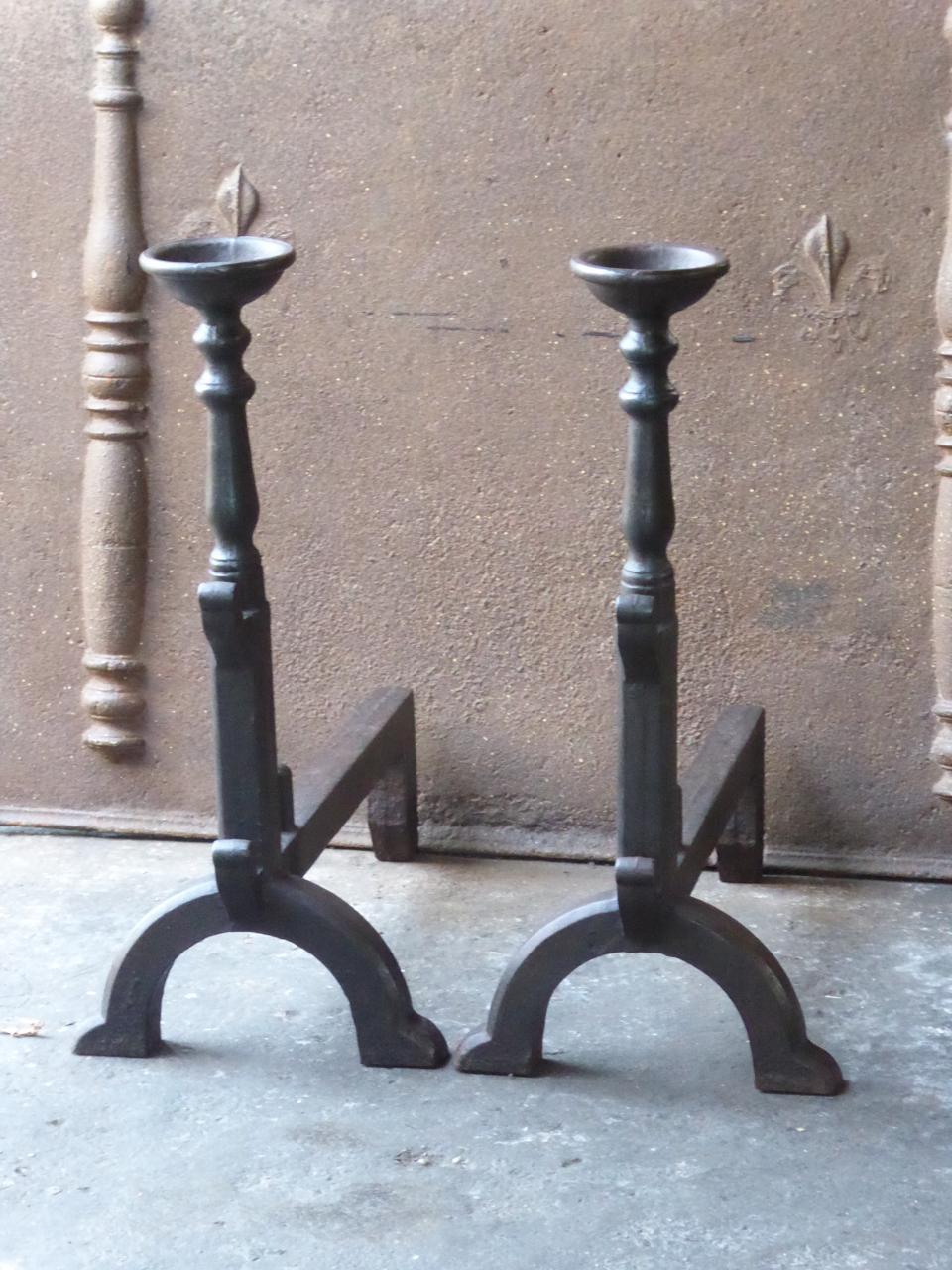 French Gothic style andirons made of cast iron. The andirons have spit hooks to grill food and cups to keep drinks warm. In France this originally very old type of andirons are called 'landiers'.

We have a unique and specialized collection of