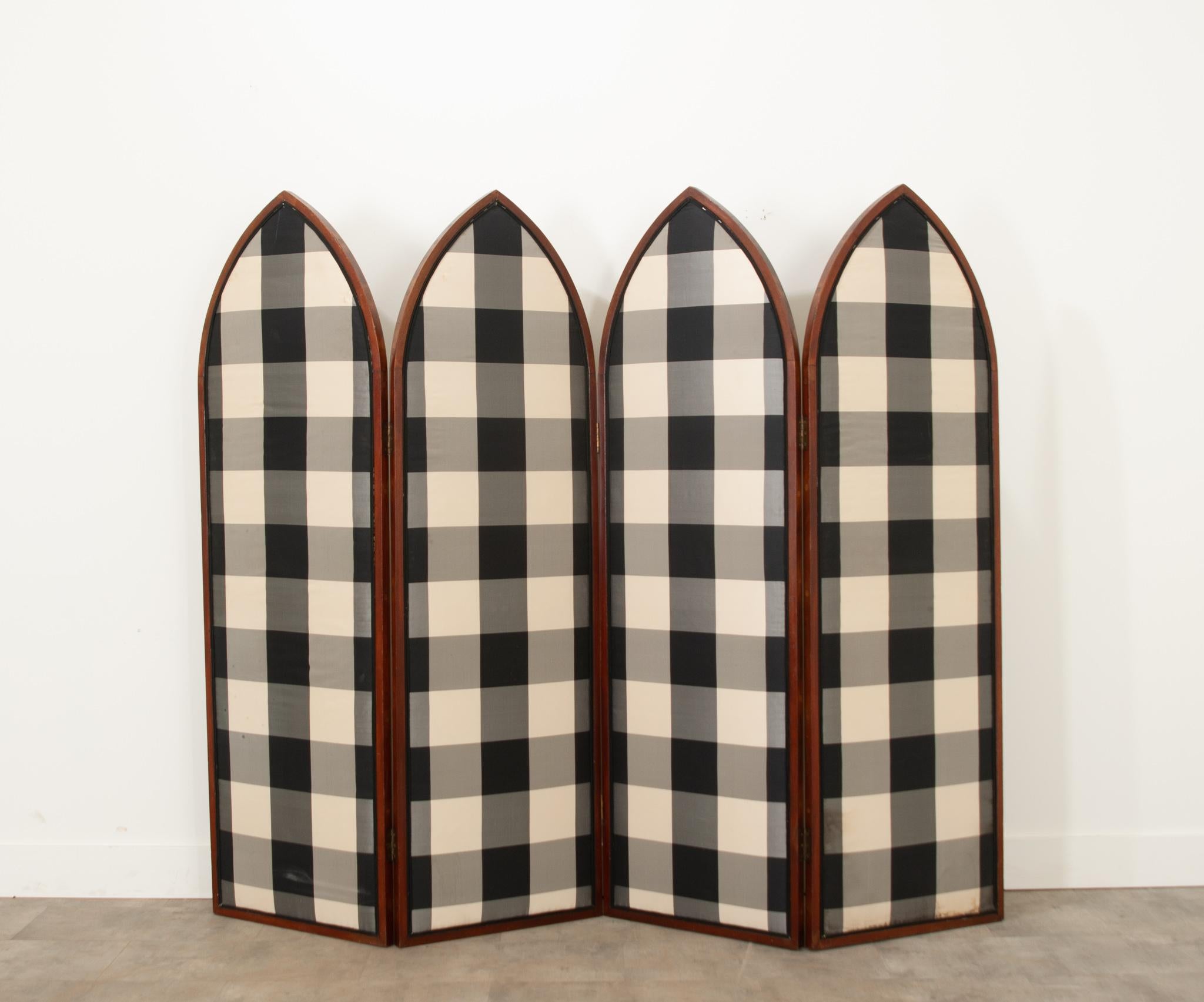 This Gothic style mahogany and silk upholstered room divider from 19th century France is an amazing functional decor piece. Each panel measures 22-?” wide and is seamlessly fixed with black, white, and gray checkered fabric with a double welt