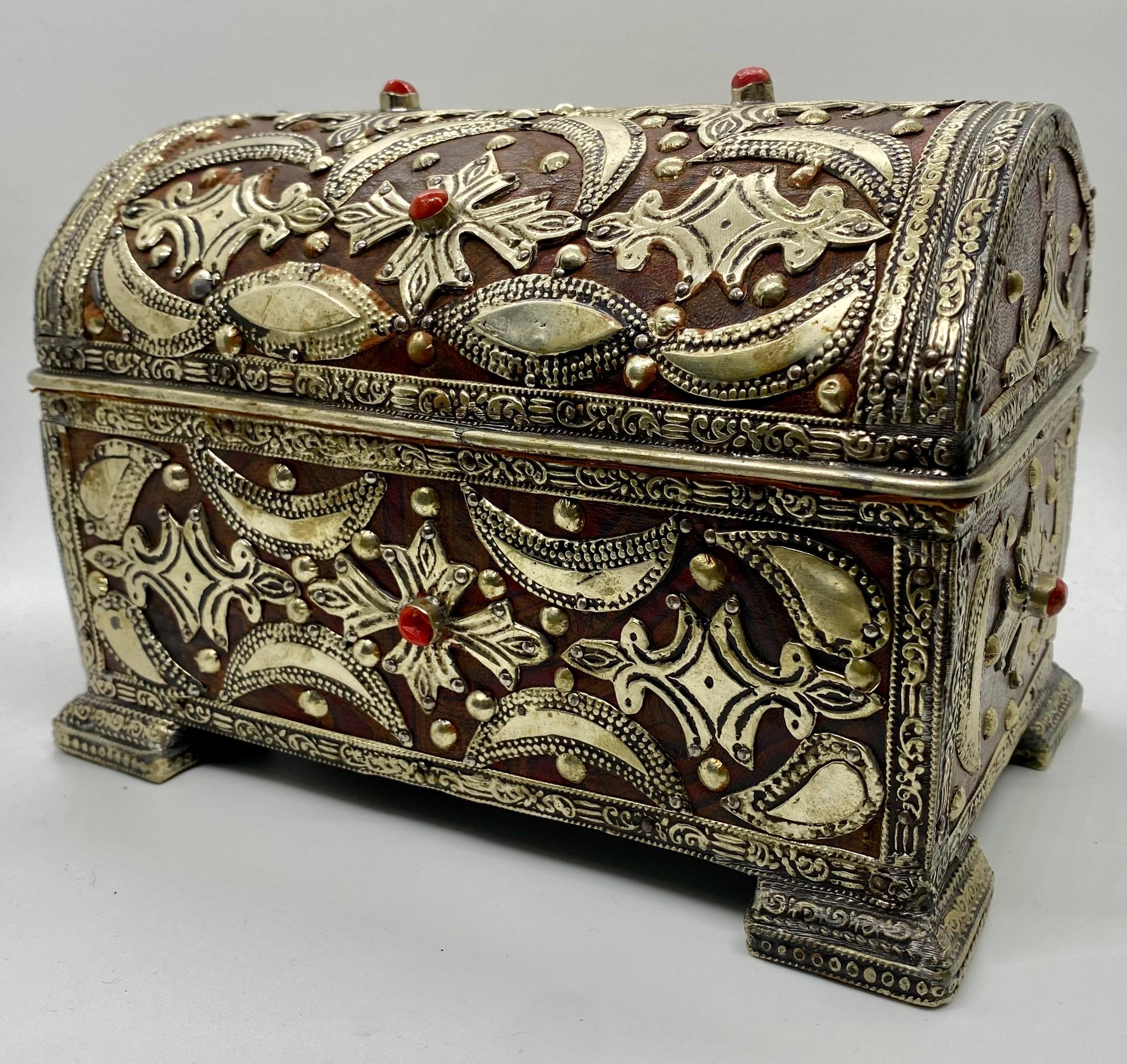 Une exquise boîte à bijoux ou un petit coffre de style gothique français, un témoignage de l'allure intemporelle de l'artisanat. Ornée d'incrustations complexes en laiton sur du cuir véritable, cette boîte dégage une aura de sophistication et