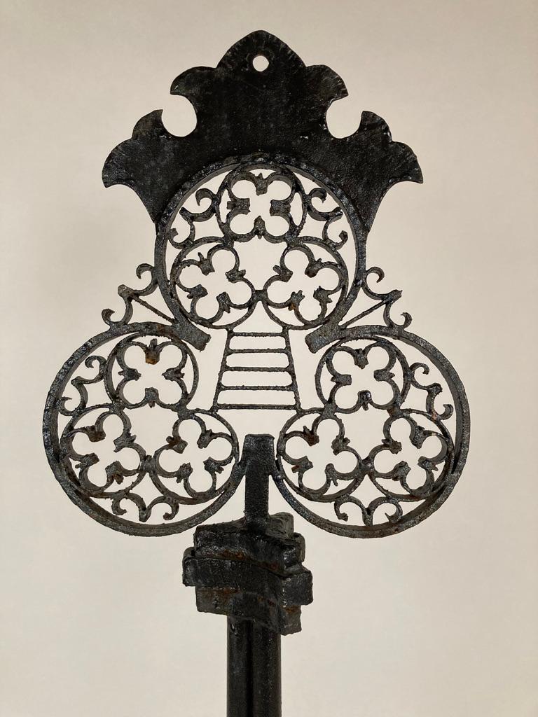 French wrought iron black painted locksmith trade sign in the form of a large and elaborate key. The trefoil top filled with interlocking Gothic style quatrefoils (like four leaf clovers), with a ladder in the center joining them and a cut metal