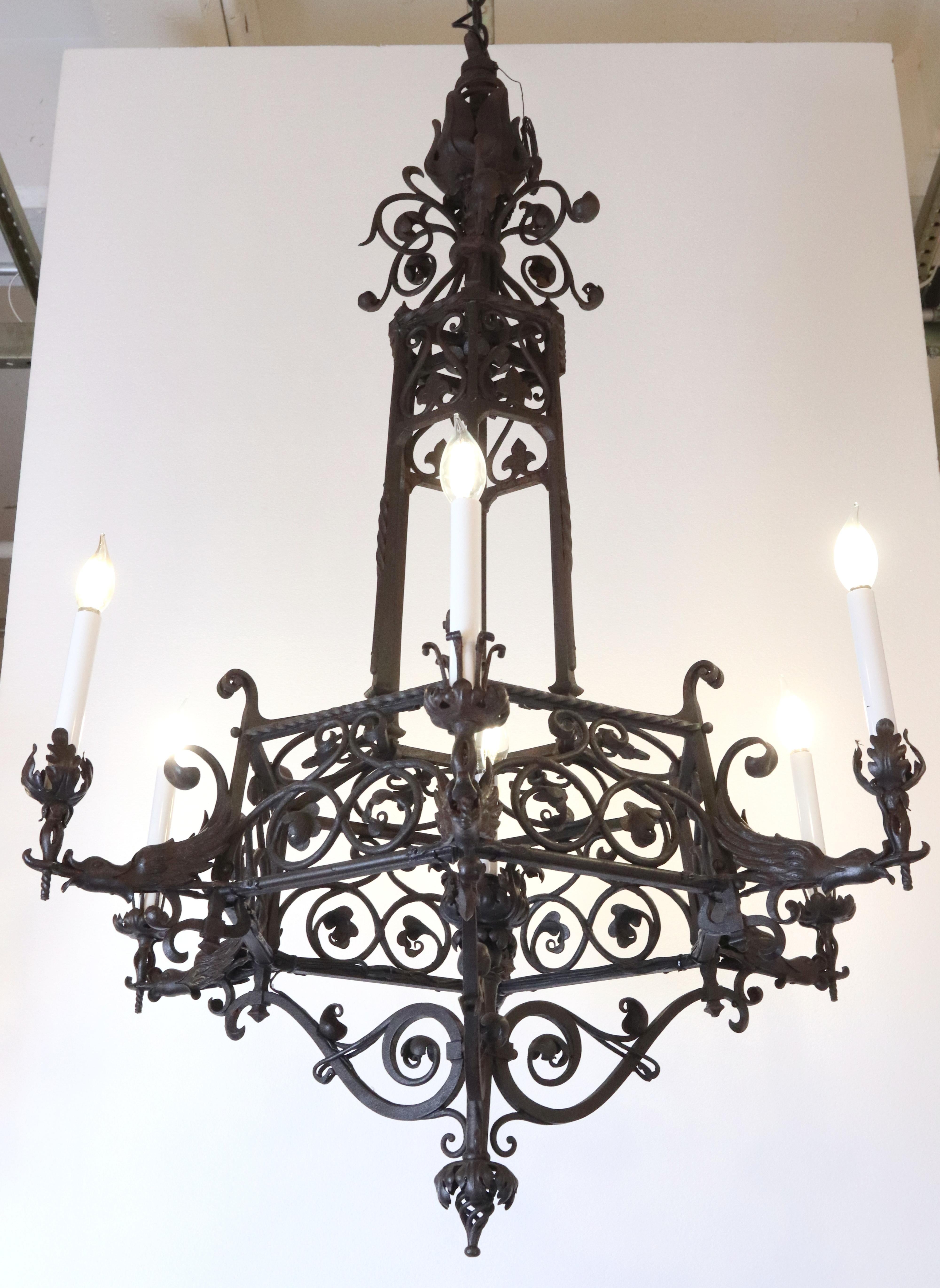 Lampadario in stile gotico francese con sei bracci in ferro battuto con finitura nera. Ha un design intricato e decorato con motivi di scorrimento e bracci decorativi a forma di uccello. Questa lampada richiede sei lampadine E-12 a candelabro.