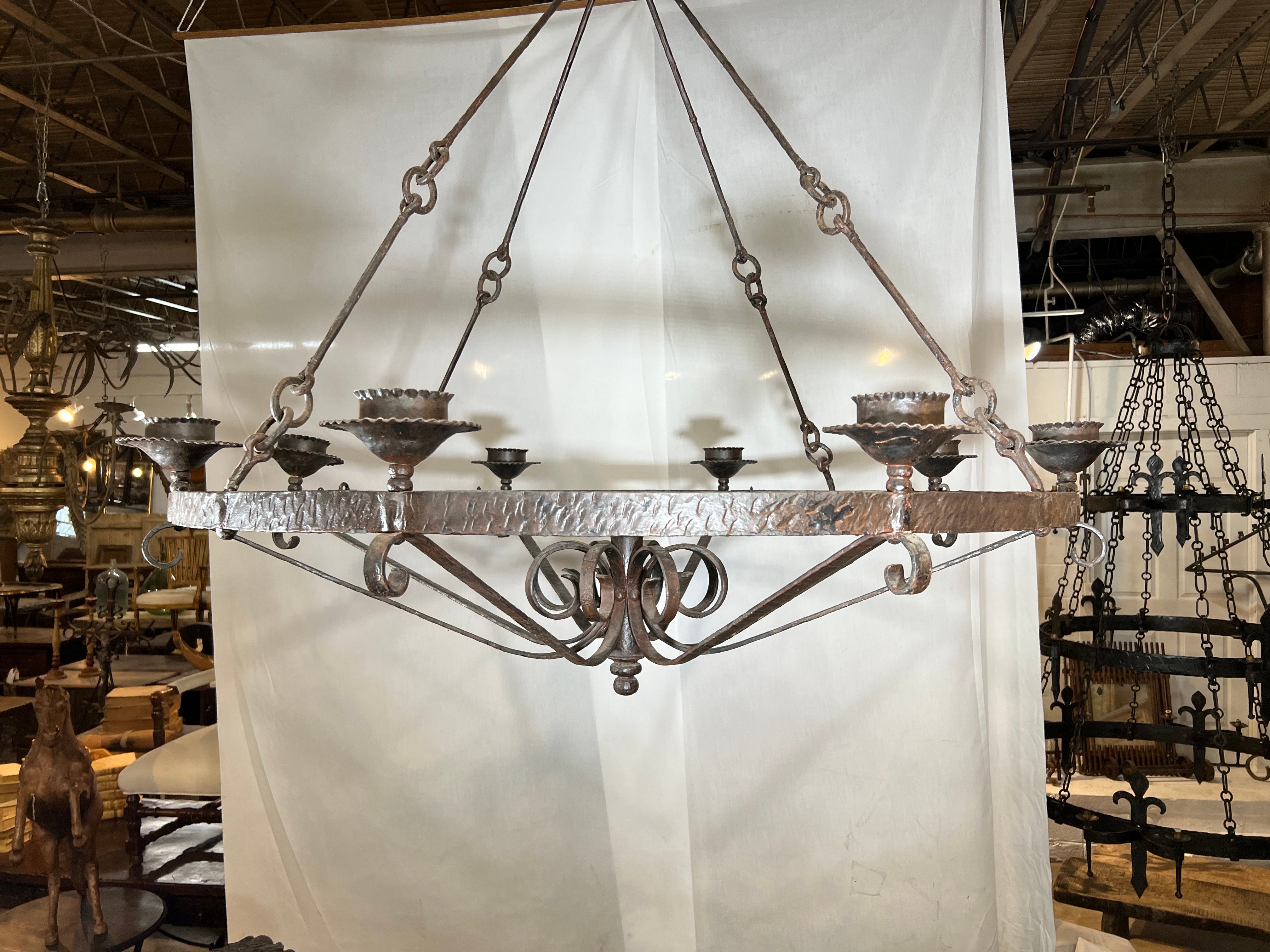 A very handsome early 20th century grand scale Chandelier from the South of France. Expertly crafted from hand forged iron with martele' detailing.