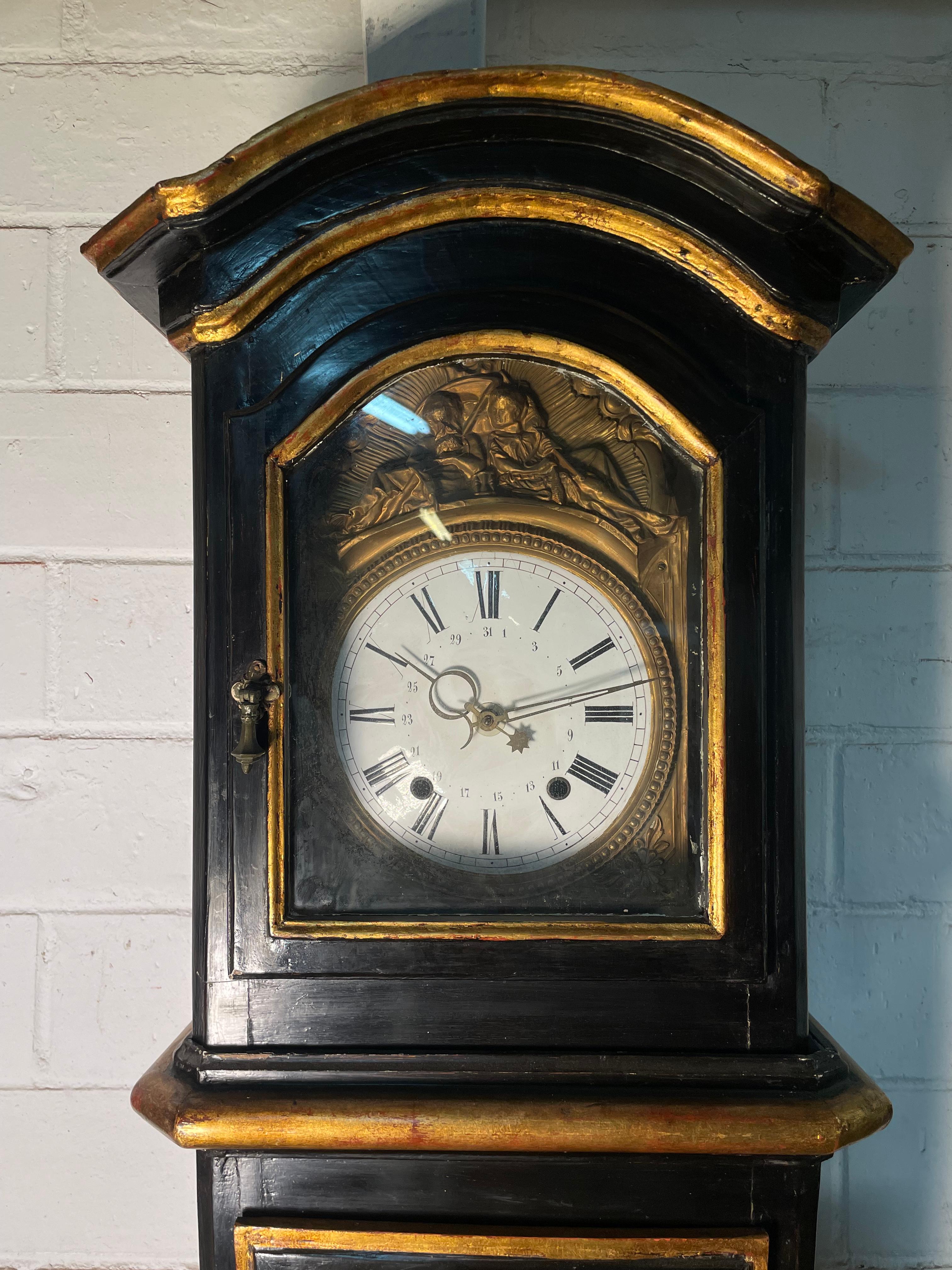 This 19th Century Grandfather Clock is decorated with hand-painted, gold leaf chinoiserie. The black lacquer case with gilded and painted Scottish landscapes; where the sheep are grazing, men are fishing and walking along a rocky road. Scenes of