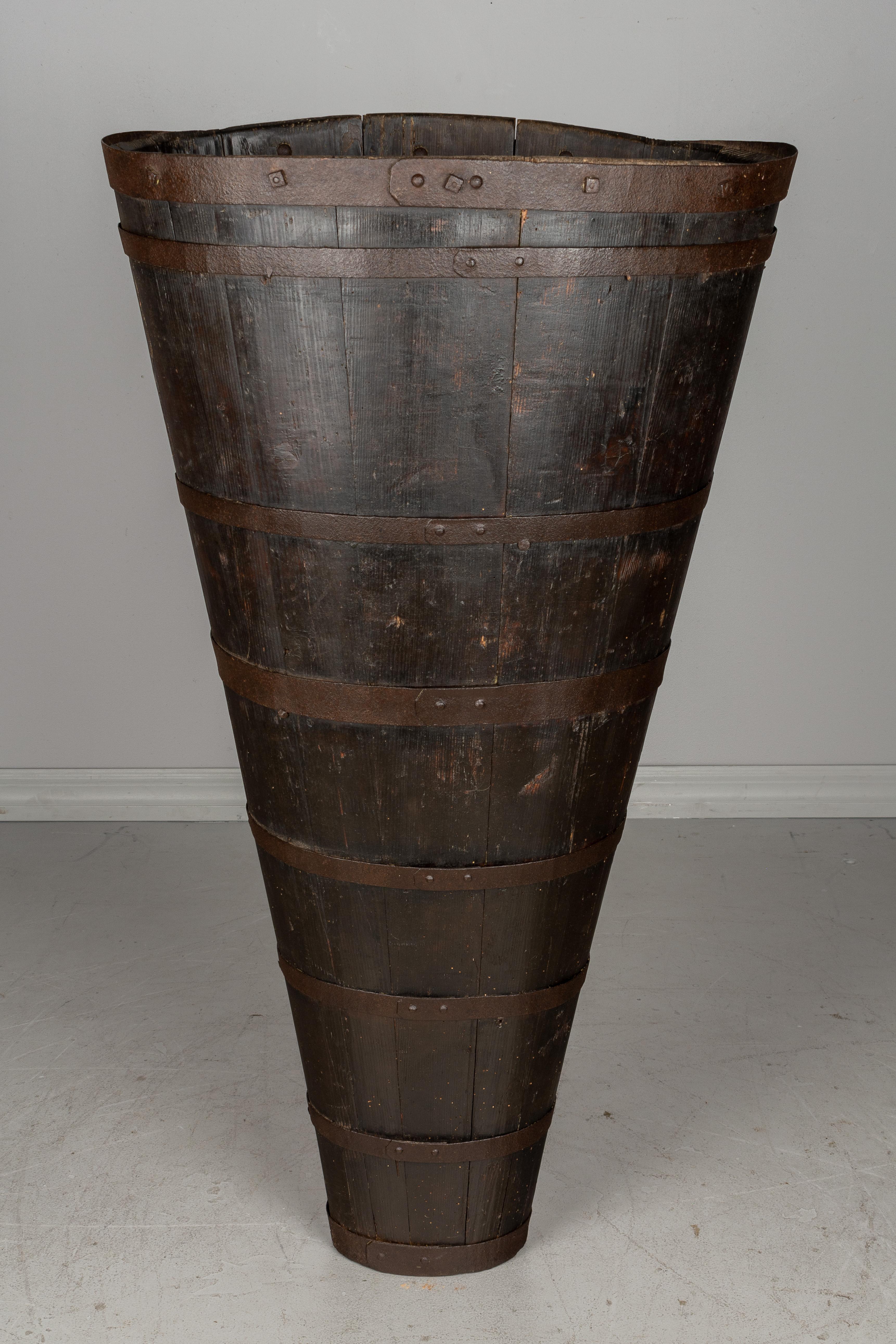 A French hotte de vigneron, or grape harvesting barrel. Used in the vineyard, this barrel was strapped to the back and used to collect and transport the grapes. Made of pine with iron binding and cast iron loops where the straps were tied. Beautiful