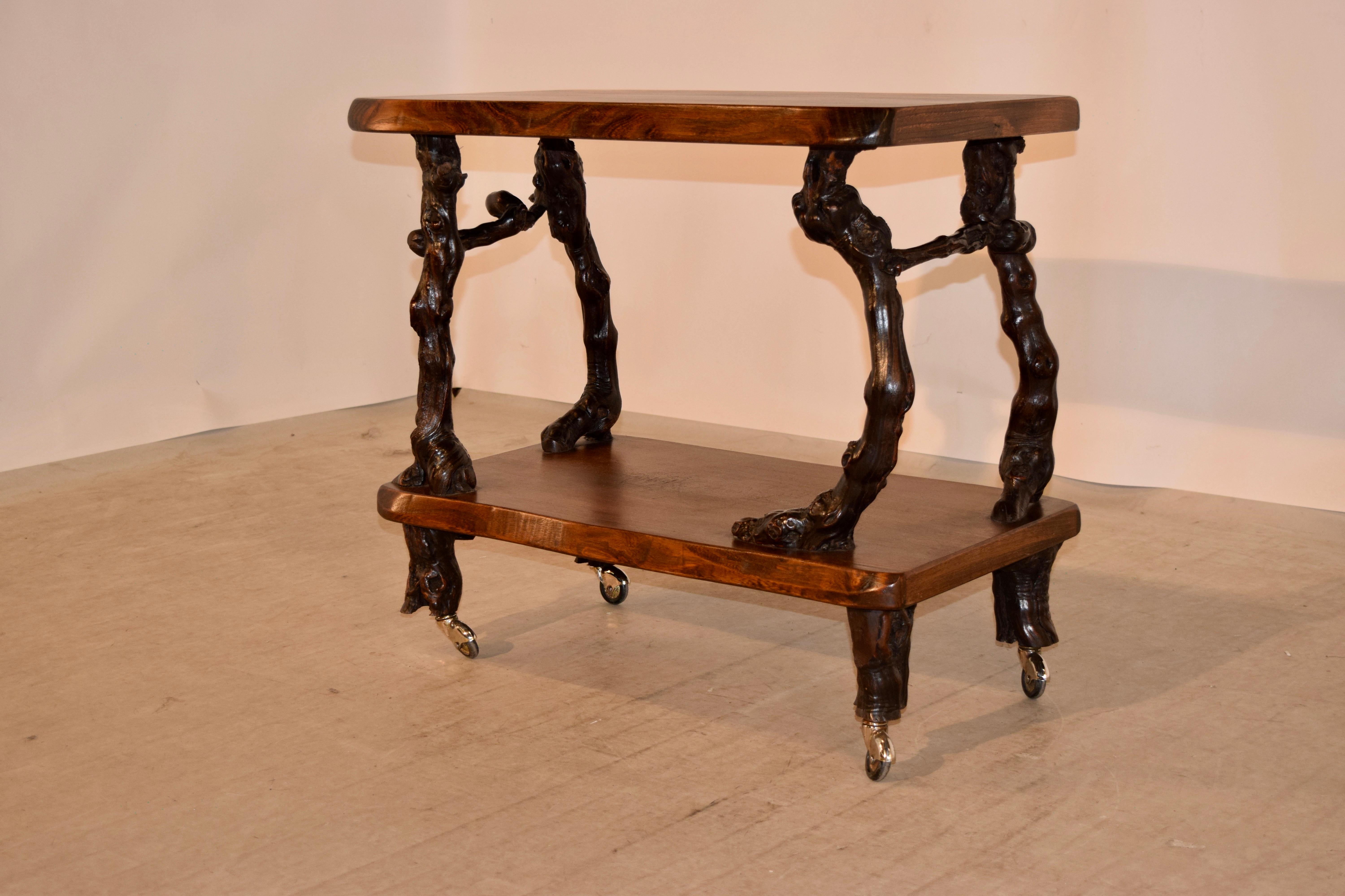 French bar cart made from walnut shelves separated by grapevine legs and stretchers, circa 1920s. The feet are also made form grapevines over original brass casters.