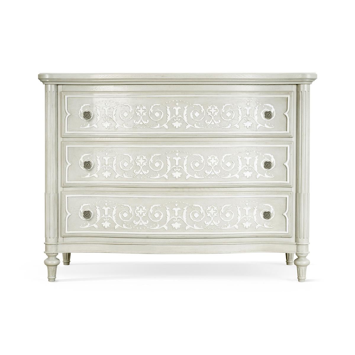 French Gray Painted Commode, embellished with an artful hand carved floral motif across serpentine drawer fronts between classically lined stop-fluted columns balanced on turned and tapered feet. 

Dimensions: 50 1/8