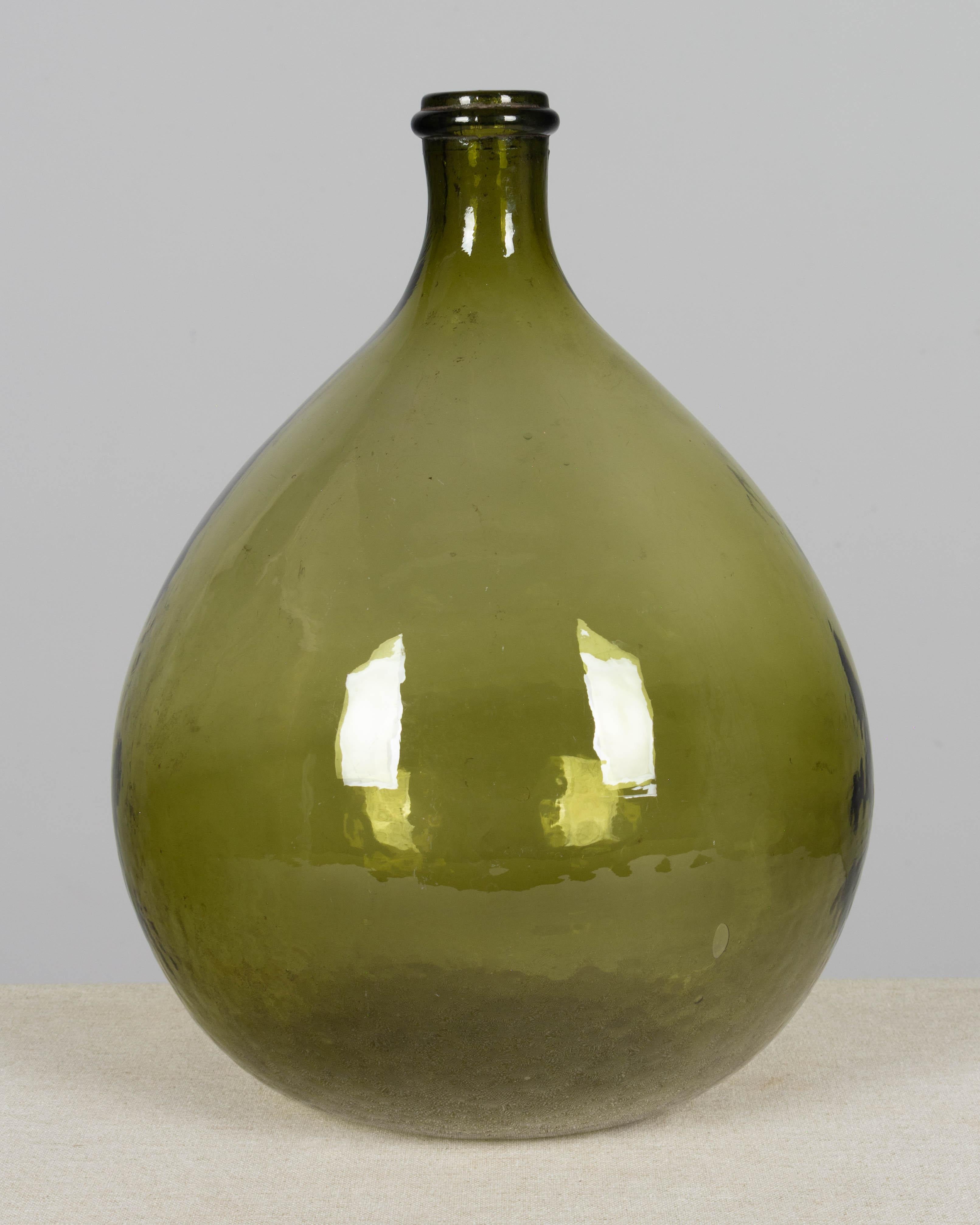 Una bottiglia a forma globulare francese del XIX secolo in vetro verde soffiato a mano, una Greene & Greene, o una damigiana. Capacità: 10 litri. Circa anni '20.
14 