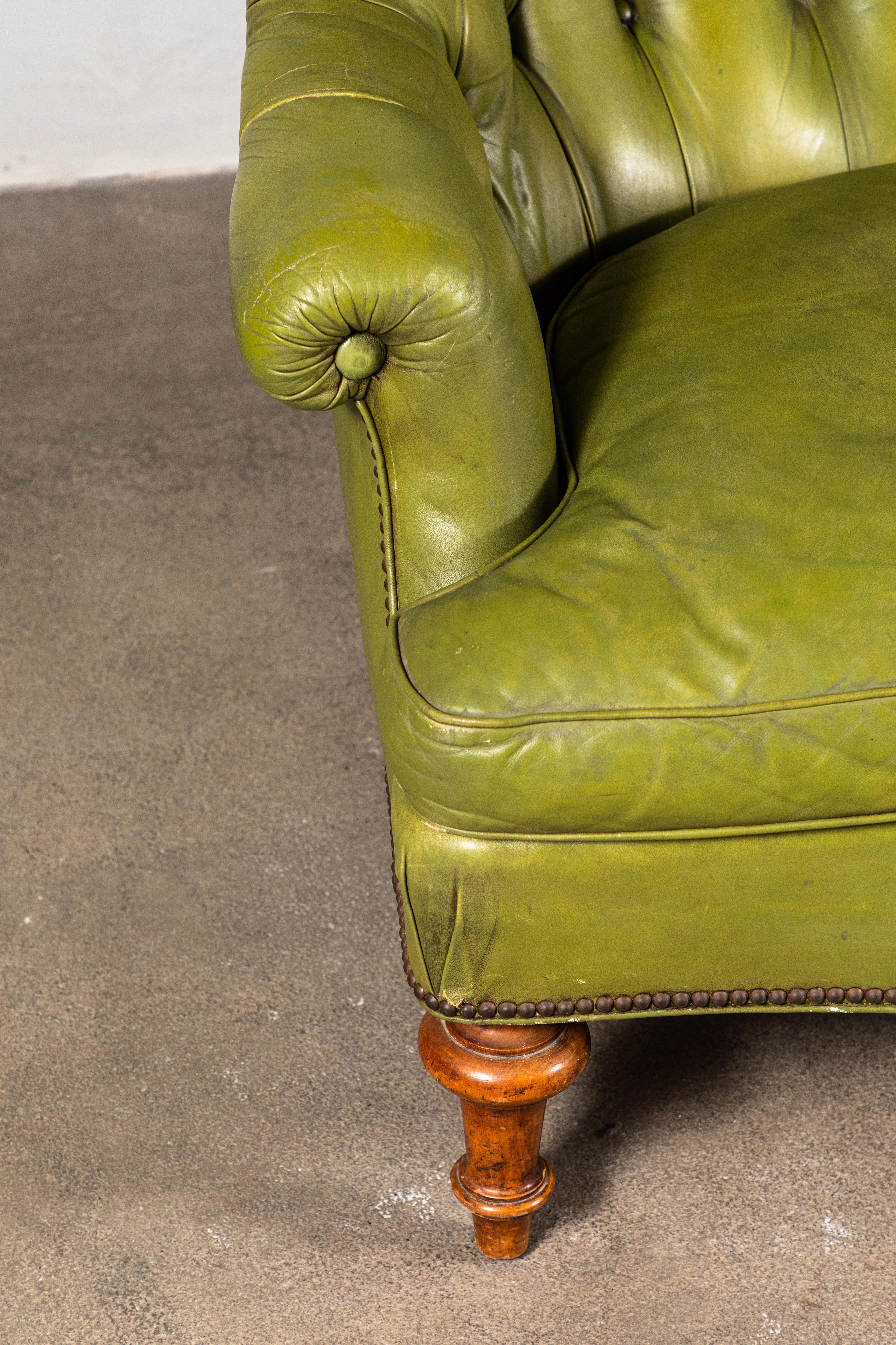 Beautiful French green leather tufted settee newly restored with turned wooden legs.
