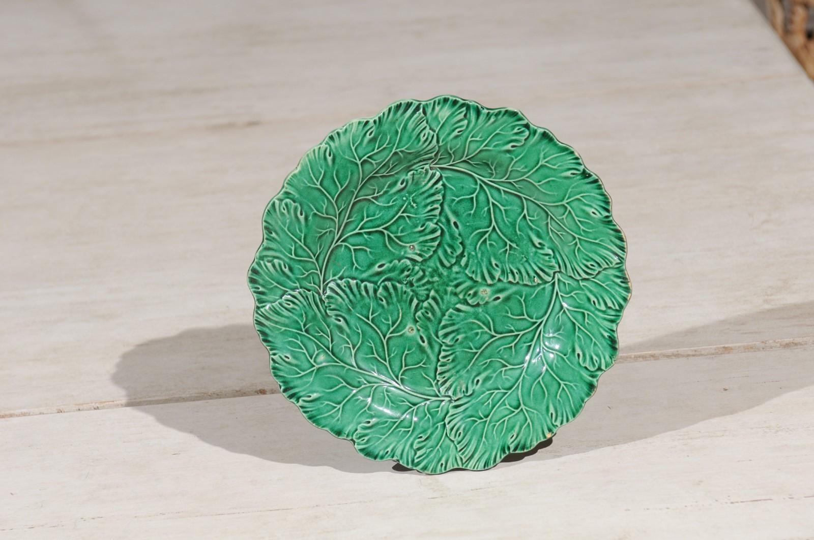 A French green majolica leaf plate from the late 19th century, with scalloped edge. Born in France in the later years of the politically dynamic 19th century, this lovely plate features a vivid green color enhancing beautifully the leafy décor of