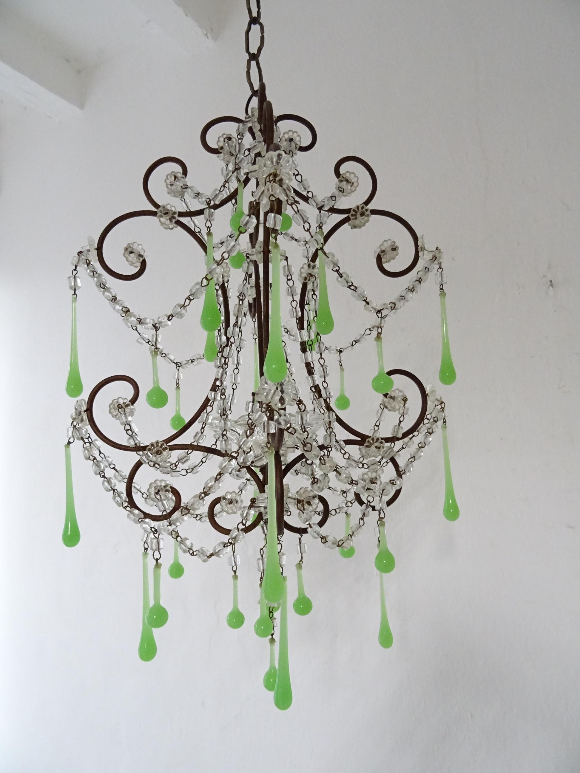 Housing one light in center in a rare shape bobeche. Will be rewired with a certified UL US socket for the USA and appropriate socket for all other countries and ready to hang. Swags of crystal macaroni and florets throughout. Adorning Murano green
