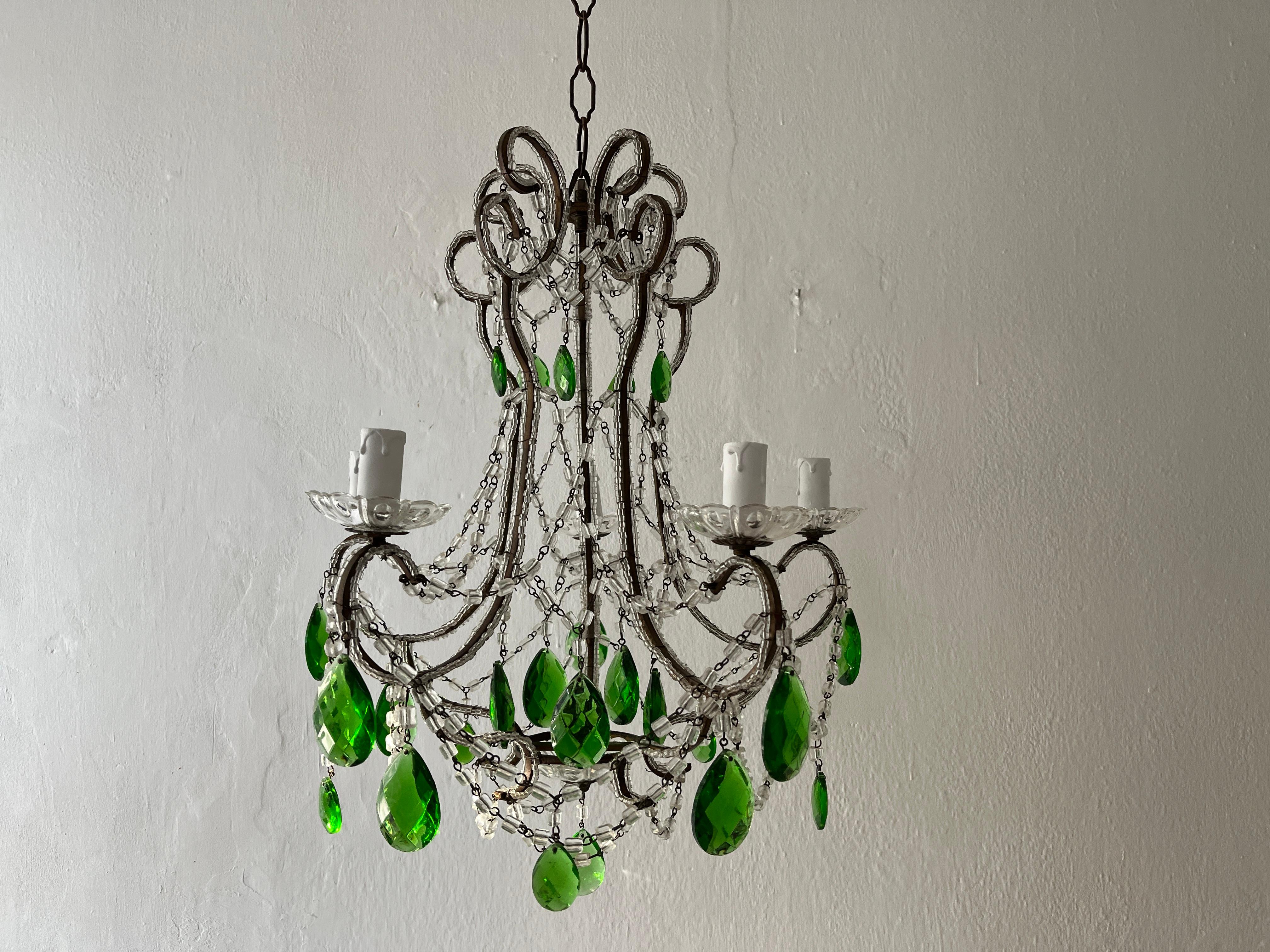 Housing 5 lights, sitting in crystal bobeches. Will be rewired with certified UL US sockets for the United States and appropriate sockets for country and ready to hang. Macaroni bead swags throughout with vintage green prisms, not missing one.