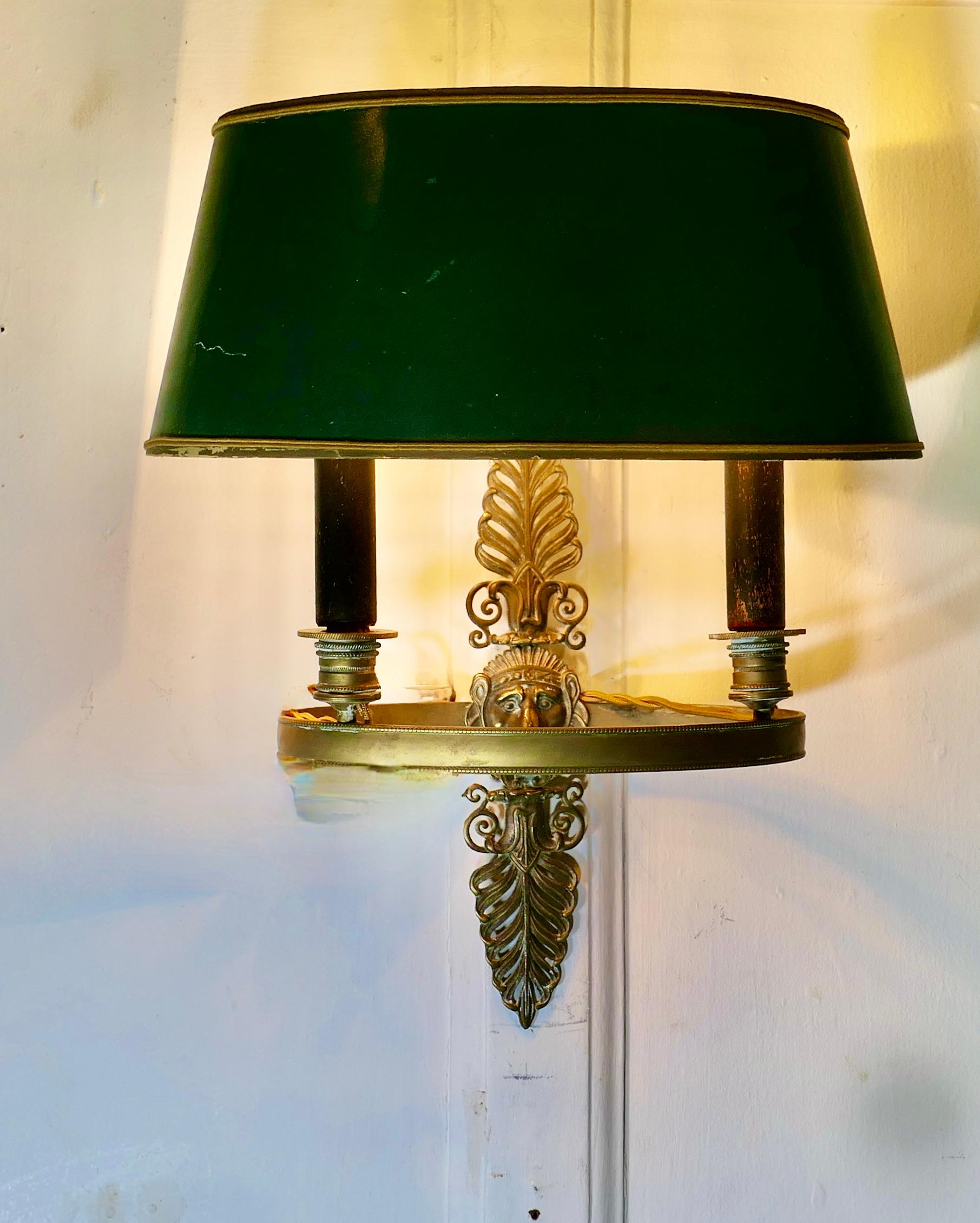 French Green Toleware and Brass Twin Bouillotte Wall Light

A lovely piece, a double brass sconce lamp with its original toleware shade 
A  Very traditional design with a centre decoration of a Lion’s Mask
The shade is in its original crackle finish