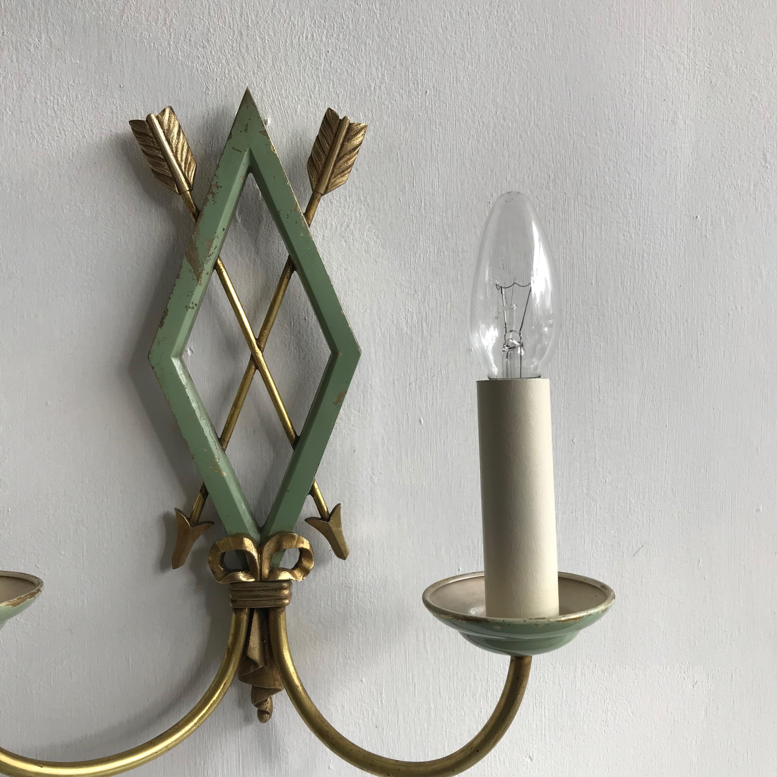 A pair of double wall lights with crossed arrow motifs. The wall lights originate from France in the early 1900s. They have been rewired and restored and each wall light requires two SES bulbs.
 