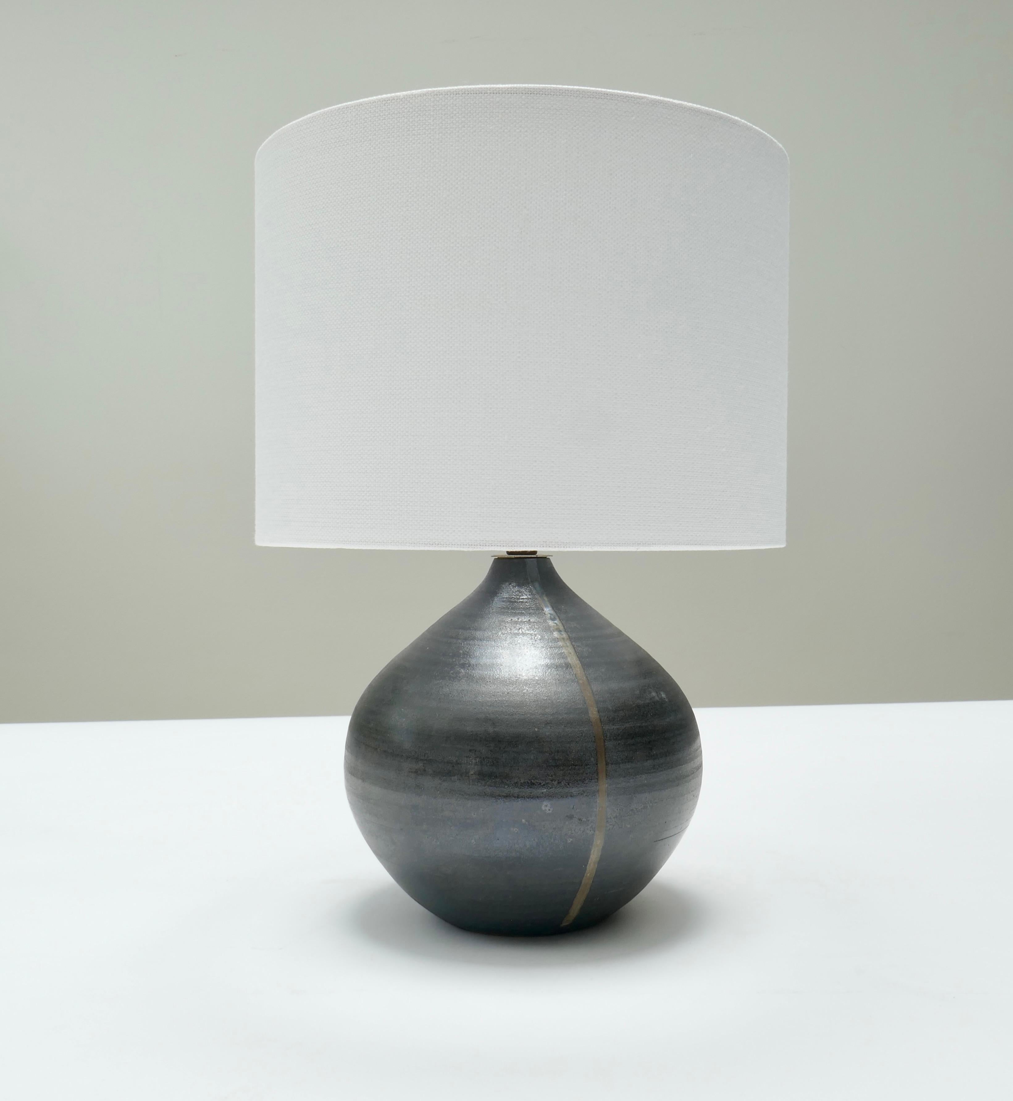 A small French stoneware table lamp in dark grey with satin glaze 
Rewired to UK standard
France Late 20th Century
Dia : 20cmx H 24
Height with lampshade 35cm