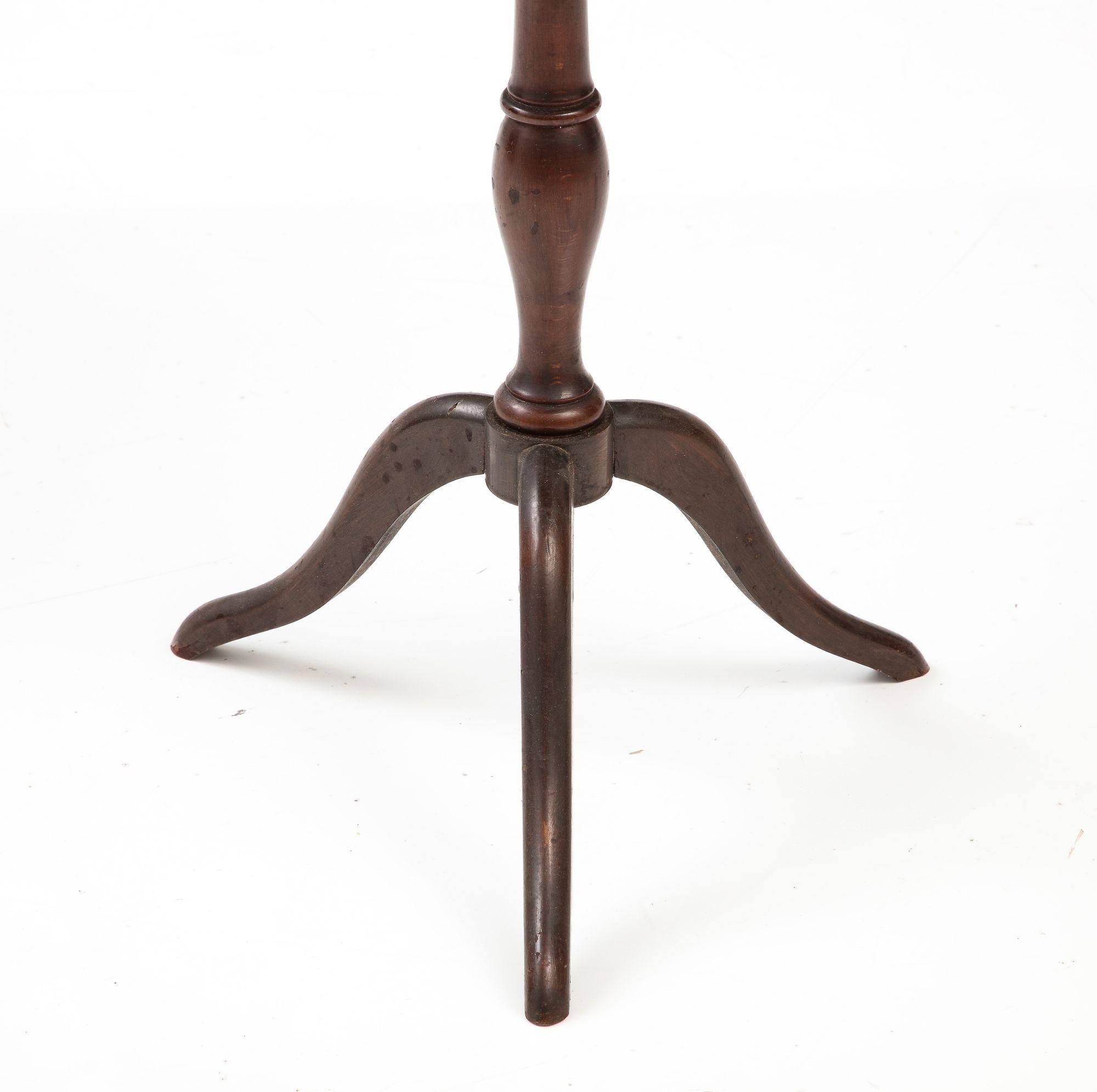 A small round French Gueridon side table from the 1940s. The mahogany veneer round top circled with a bronze edge. Wear consistent with age and use.