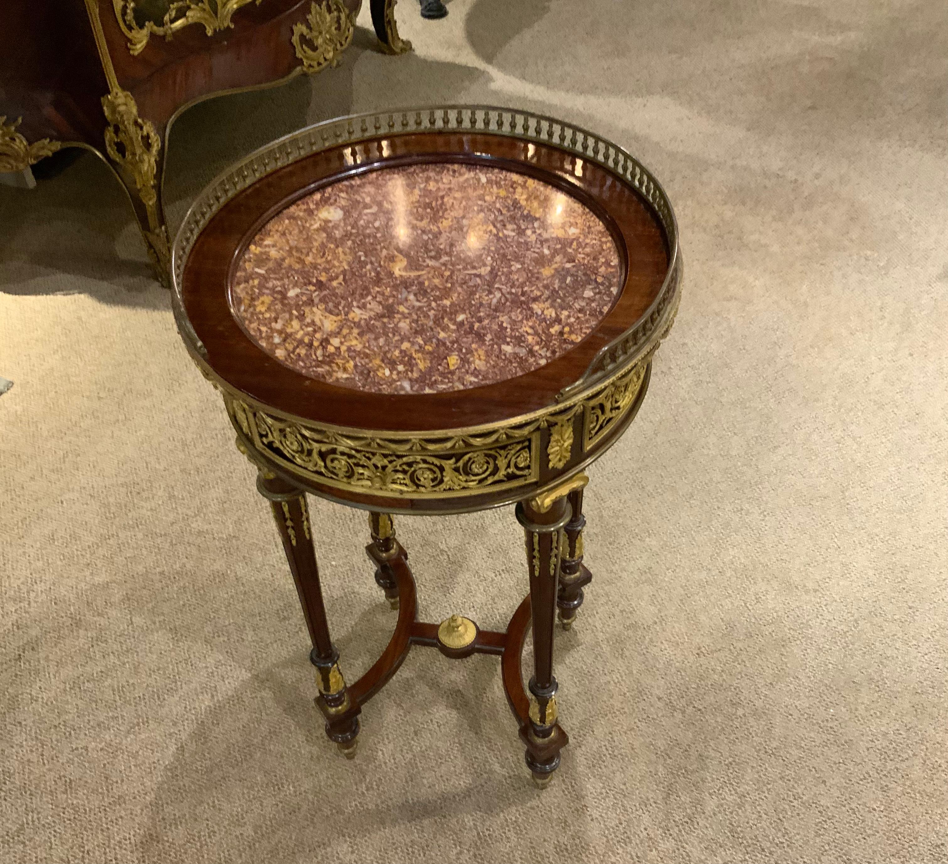 Louis XVI Style table with marble top and fine bronze
Mounts.  Tapered and fluted legs end in a toupie foot.
It has a stretcher between the legs with a centered
Finial.