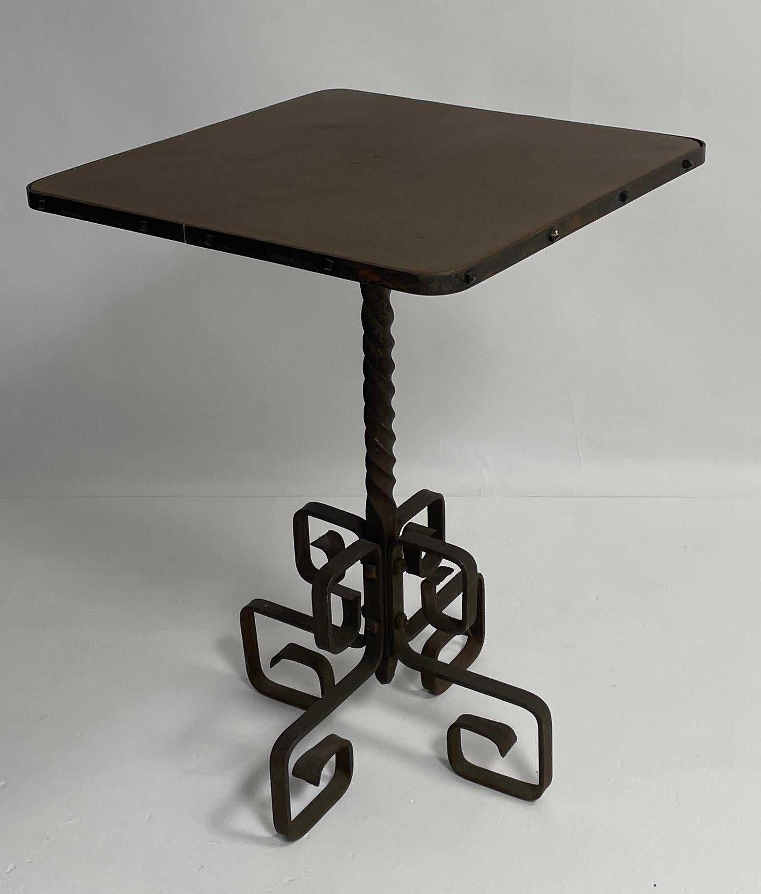 French provincial side table. This high top table has beautiful details on the iron base. The oxidized base is in great condition for its age. The table top has been recovered with an lizard embossed brown leather.