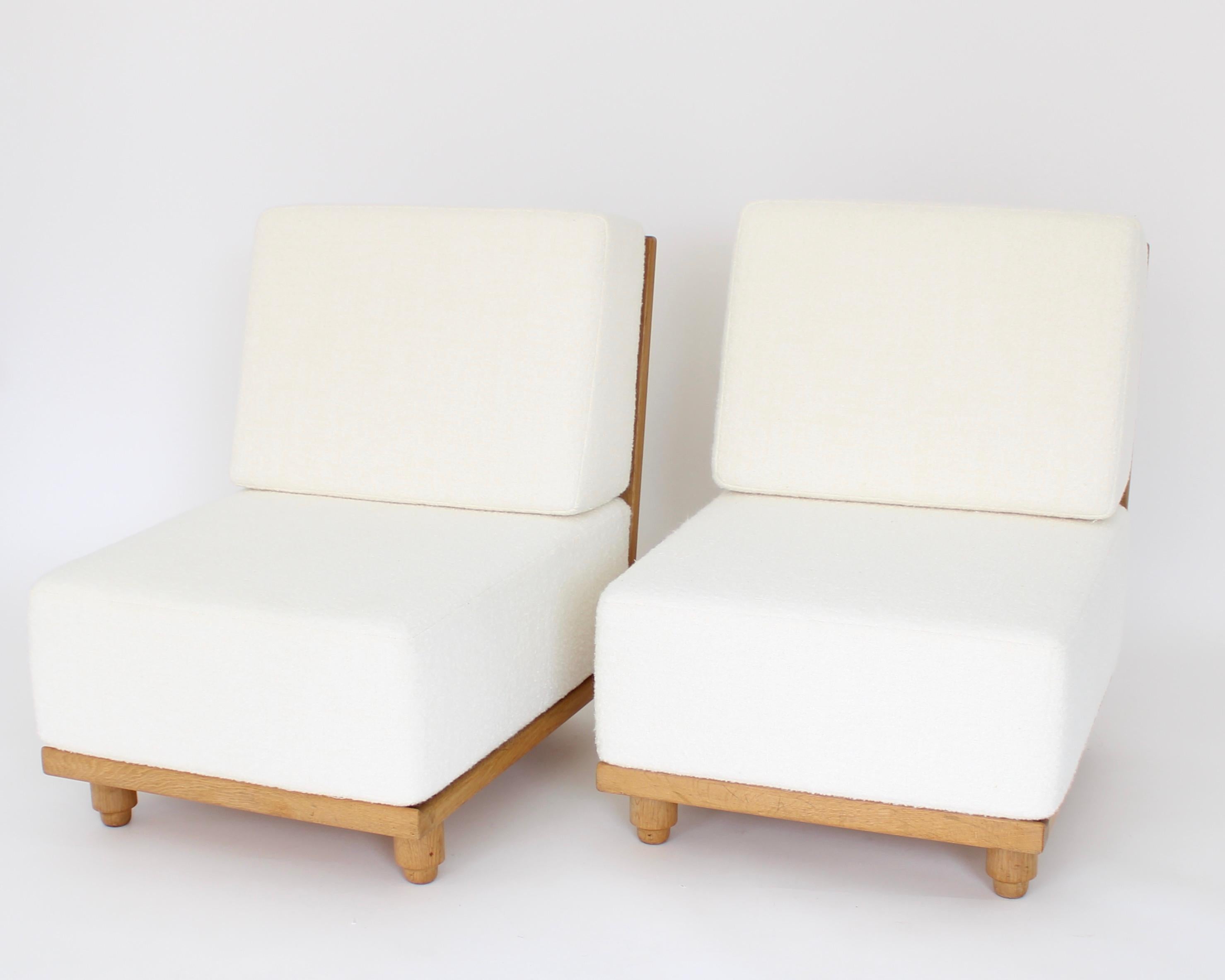 Two French Gullerme et Chambron or Guillerme and Chambron lounge chairs in natural oak for Votre Maison. 
This pair of the model Elmyre lounge chairs have a very deep and thick cushion that raises the sitter off the floor as a more typical lounge