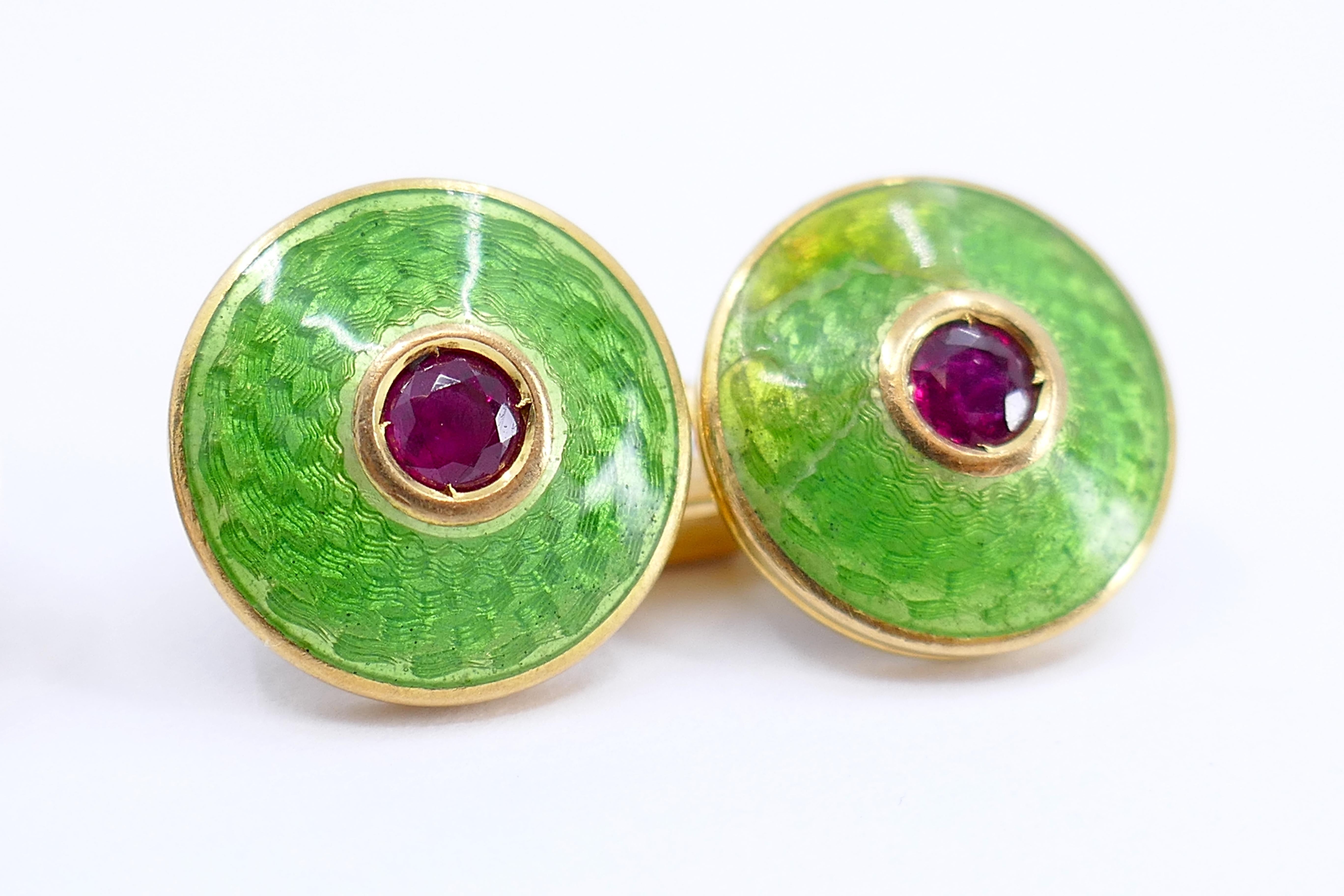 These French cufflinks, crafted in the 1930s, showcase a vibrant and sophisticated design. Made with 18K gold, the cufflinks feature a bright green guilloche enamel pattern that adds a touch of elegance. Each link is adorned with rubies, totaling