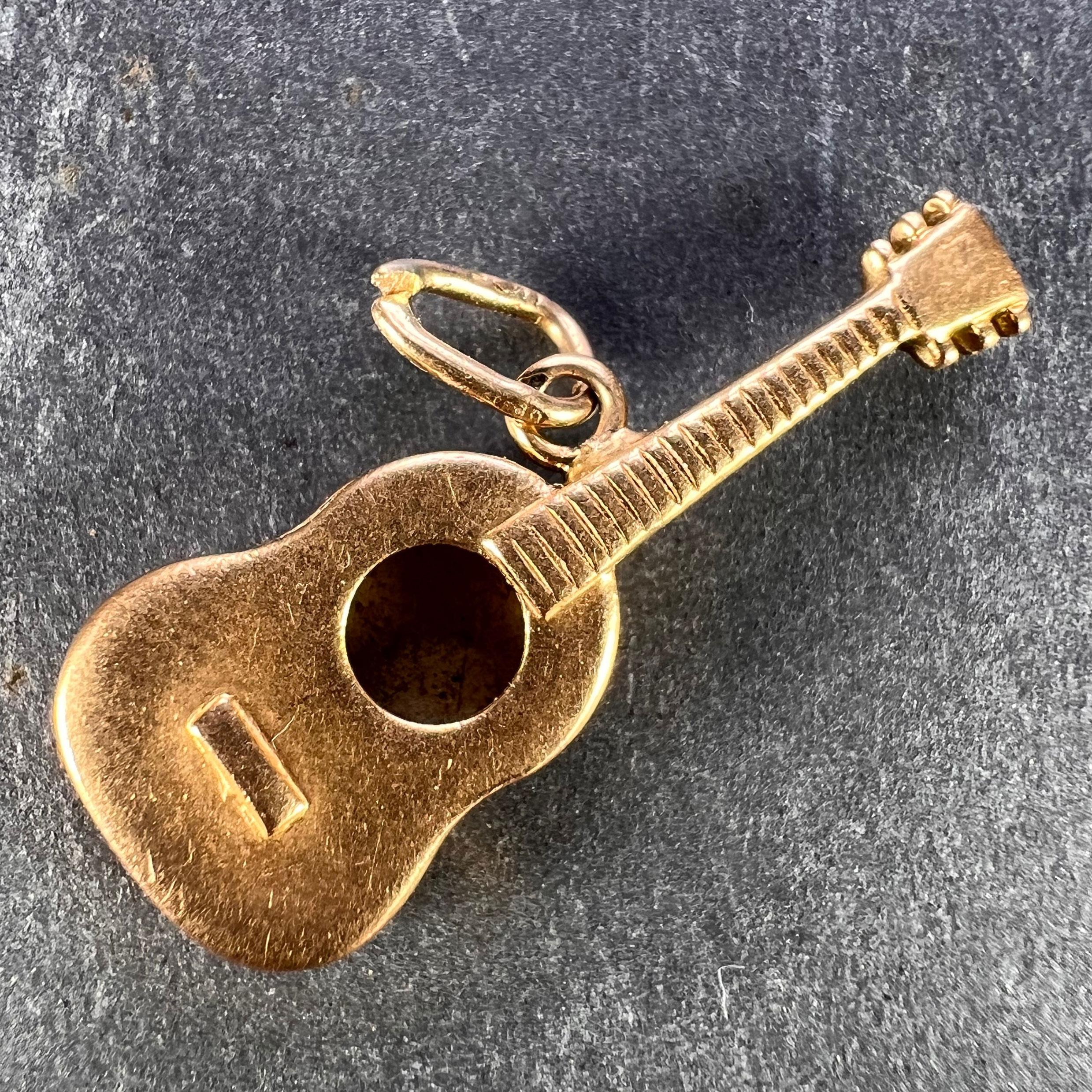A French 18 karat (18K) yellow gold charm pendant designed as a guitar. Stamped with the eagle's head for French manufacture and 18 karat gold.

Measurements: 2.5 x 1 x 0.35 cm (not including jump ring)
Weight: 1.68 grams
(Chain not included)