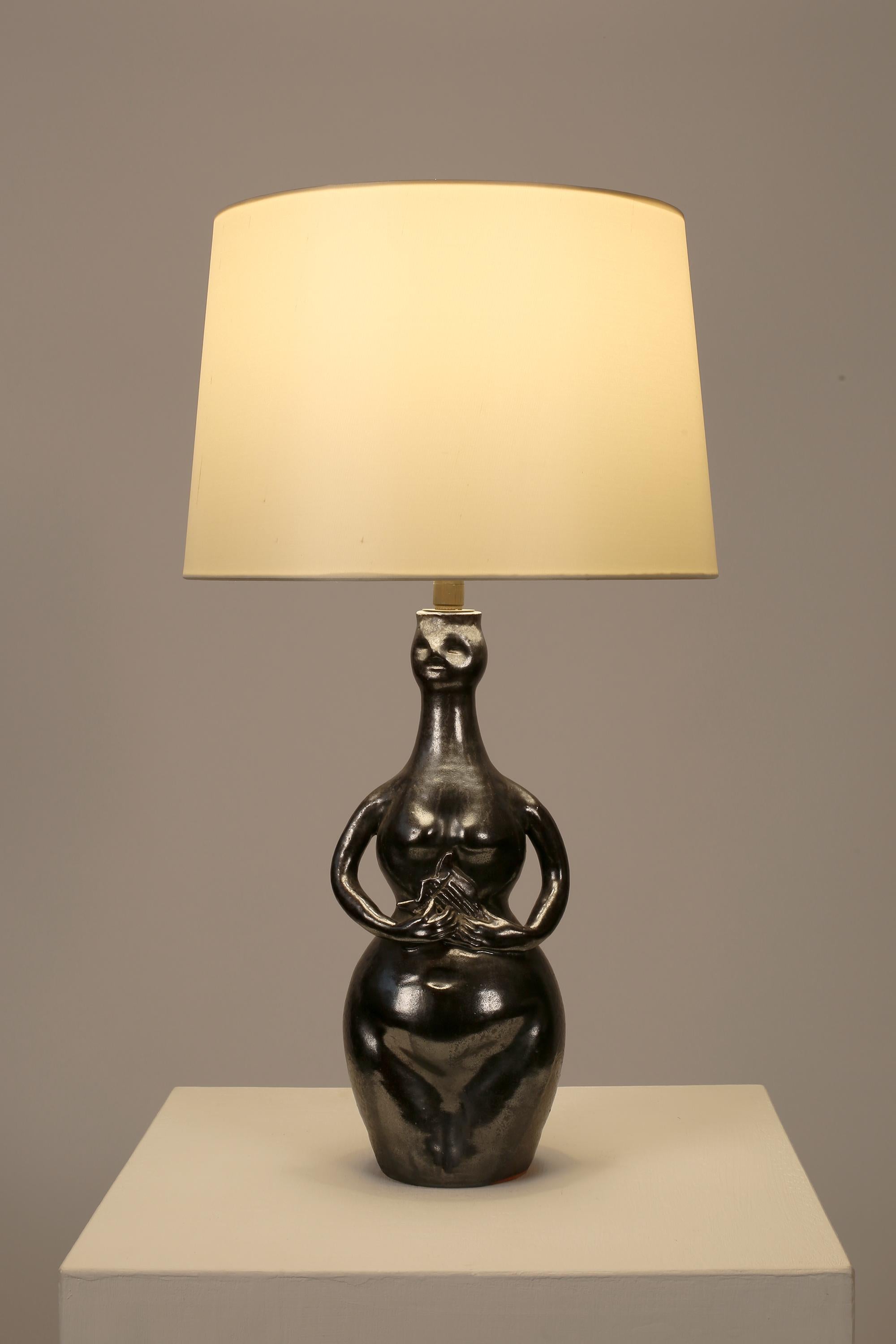 Fina lámpara de sobremesa de cerámica esmaltada en bronce de cañón, representando un desnudo femenino tocando la lira. Lamentablemente sin firmar, pero muy a la manera de Georges Jouve. Francés, c. 1950s. Se suministra con una pantalla cónica de