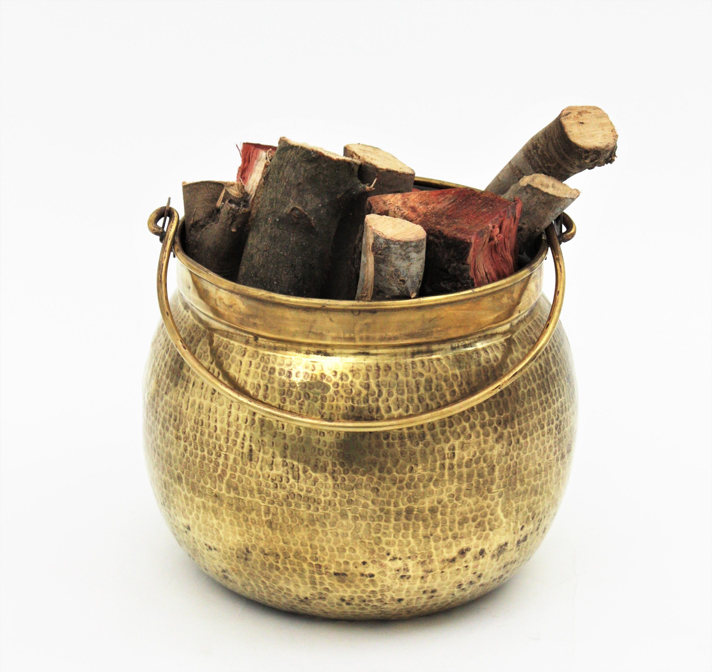 Large hand-hammered brass cauldron with brass single handle. France, 1930s.
This handcrafted brass cauldron has a gorgeous aged patina. The brass is heavily marked by hammer work.
Its large size allows to be used as log holder, decorative storage