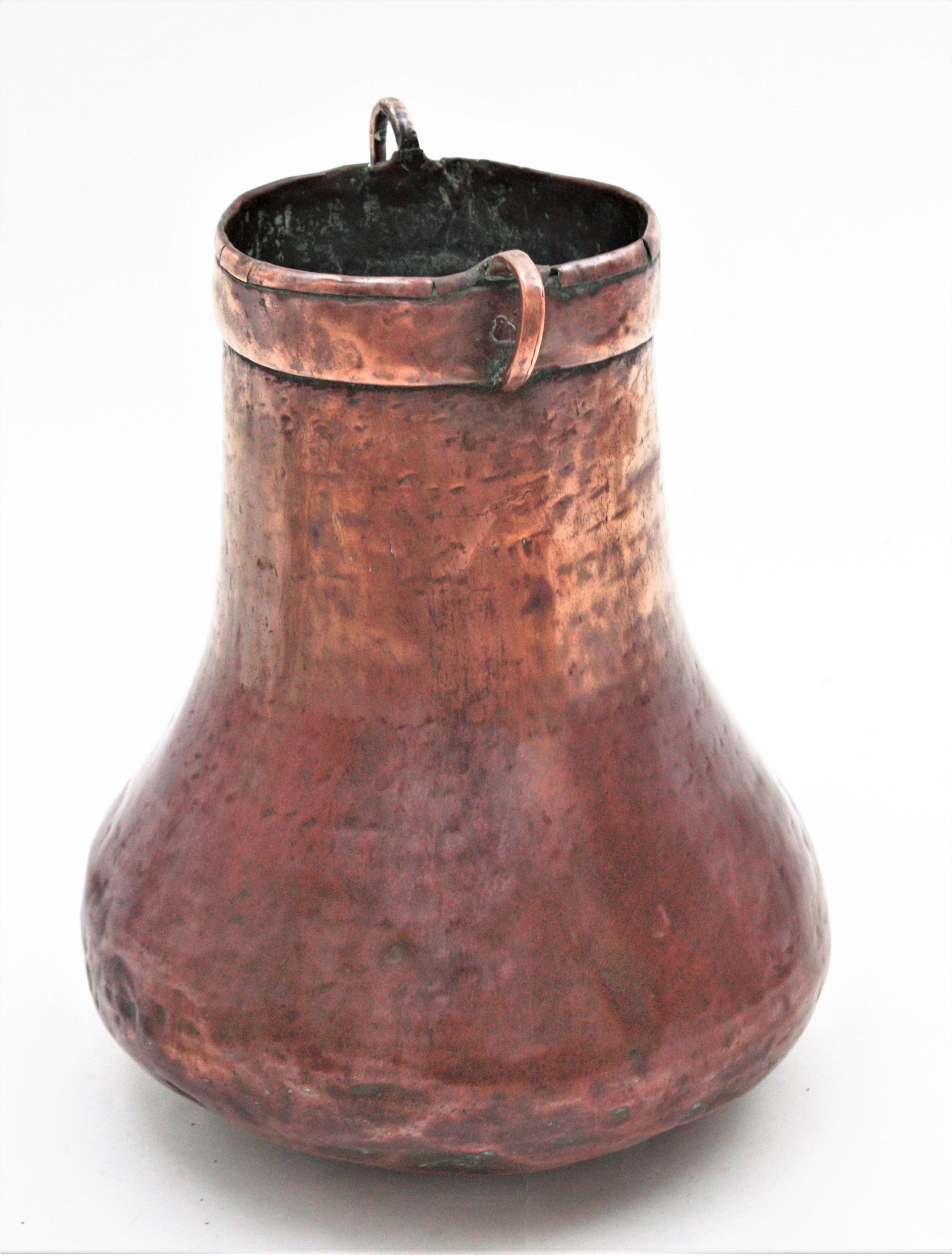 Antique hand-hammered tall copper cauldron with handles. France, 1920s.
This handcrafted copper cauldron has a nice design and a terrific aged patina. The copper is heavily marked by the pass of time and it has a strong visual effect.
Copper