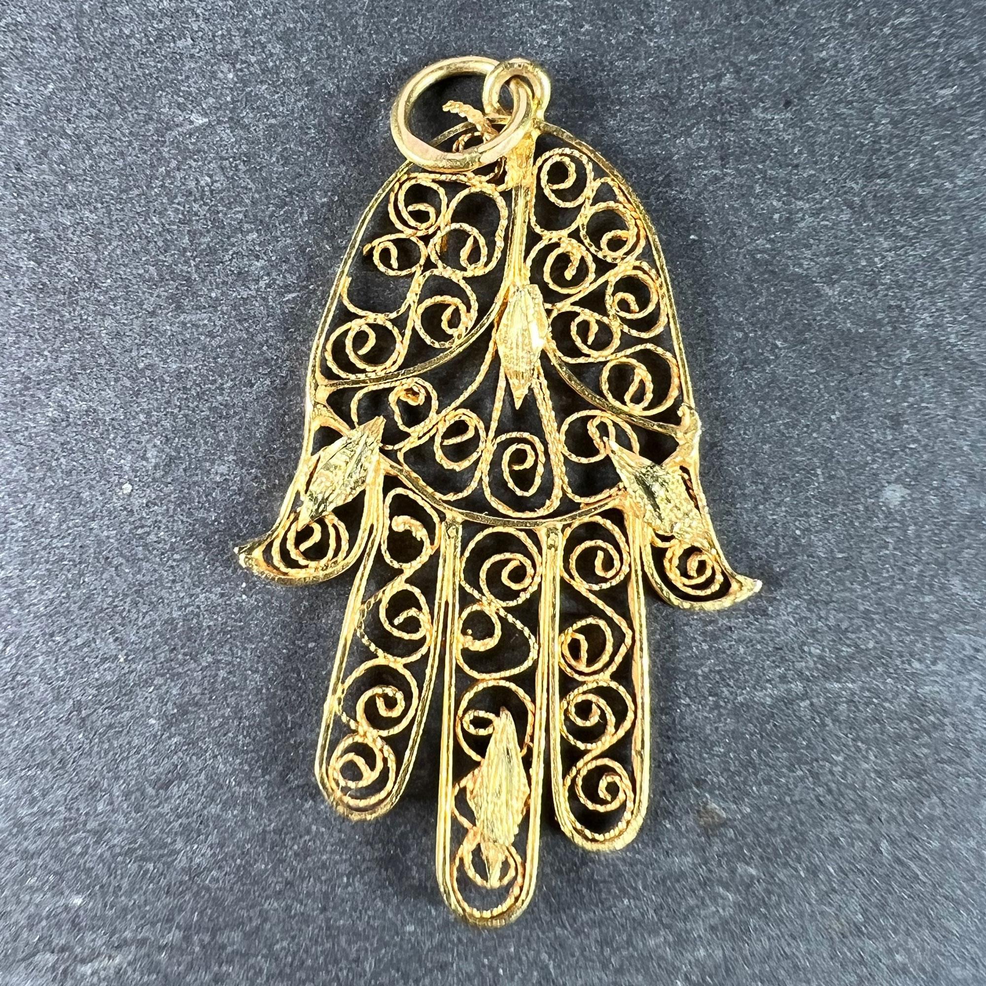 A French 18 karat (18K) yellow gold charm pendant designed as the protective amulet of a Hamsa hand, with twisted filigree wirework filling the frame. Stamped with the horse's head for French manufacture and 18 karat gold.
 
Dimensions: 2.9 x 1.8 x