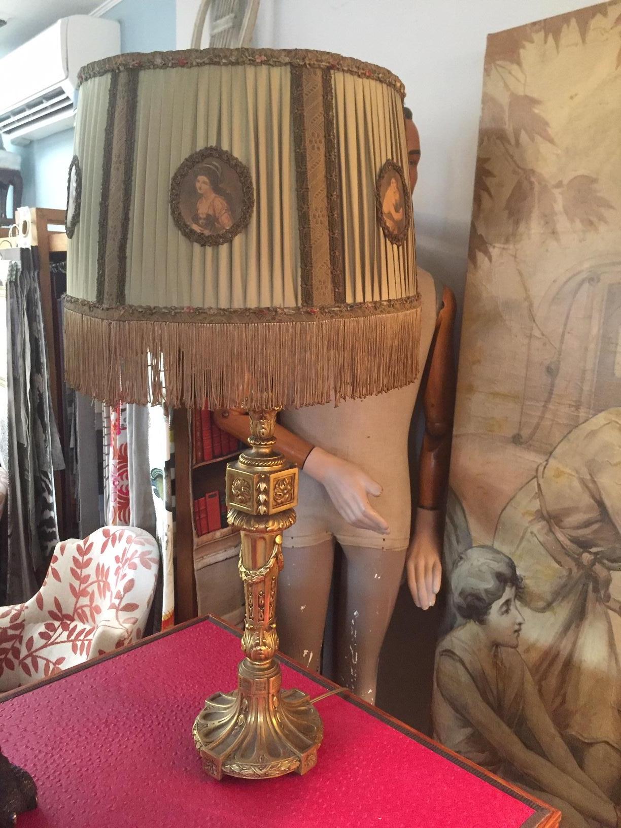 Beautiful French hand carved golden wood Louis XVI style table lamp from the 1900s with a beautiful green fringe lampshade. Female faces are hand embroidered on the lampshade.
Very elegant table lamp.