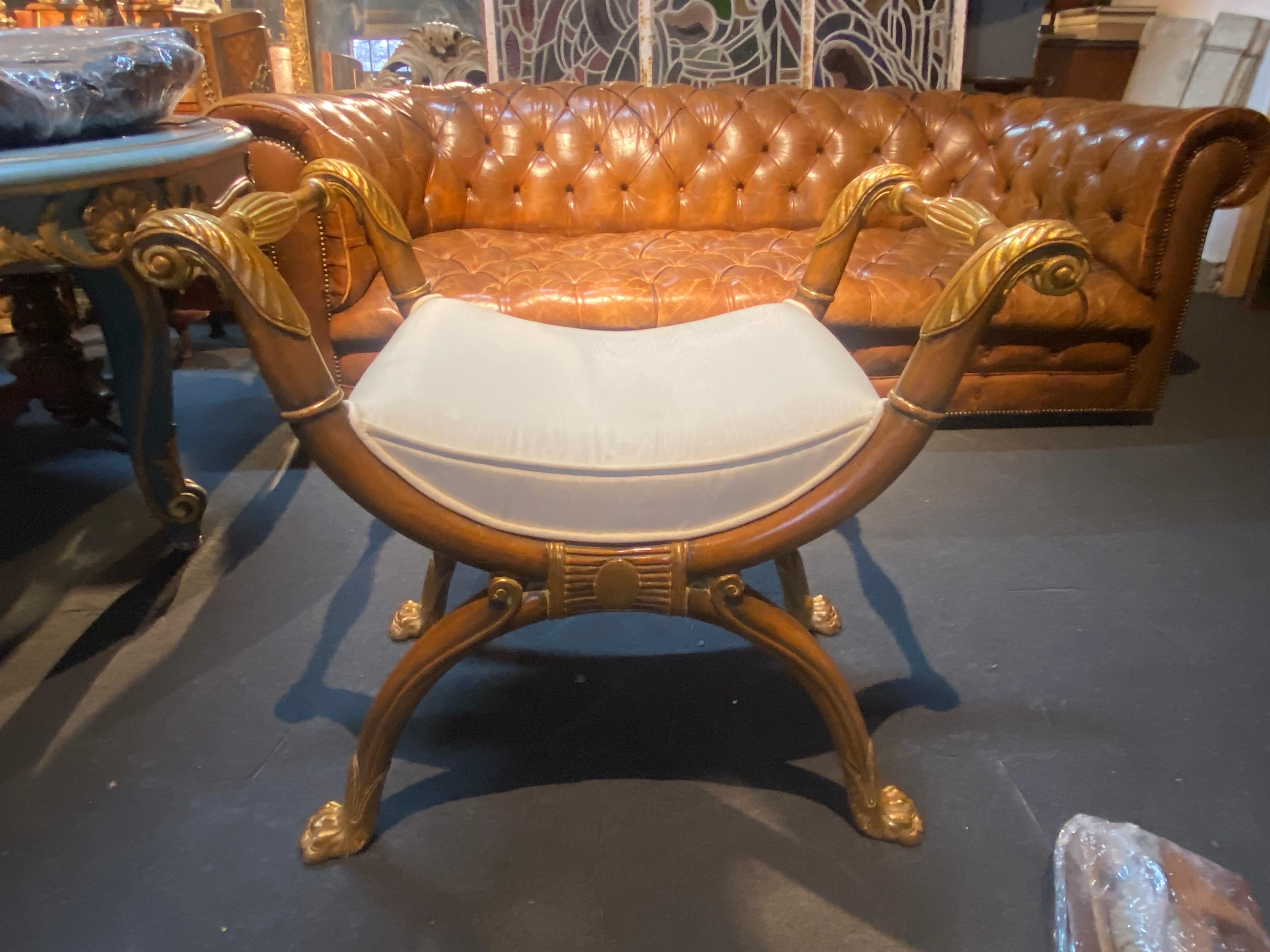 Comfortable French mahogany Savonarola stool raised on gracefully curved legs end with stylised gilt wood lion's paws. The seat is upholstered in white cotton fabric. 
France, circa 1930.