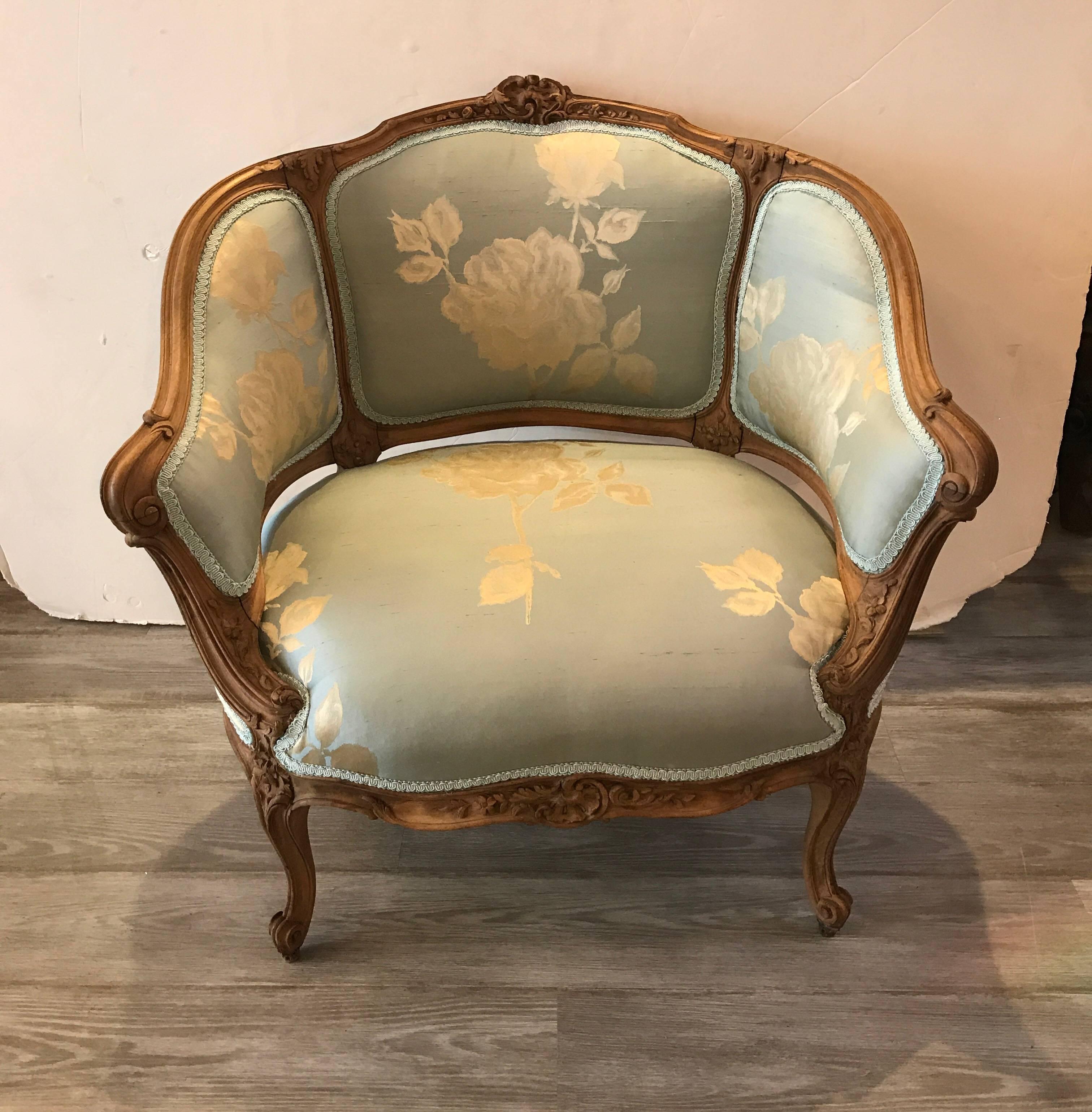 Curvaceous natural walnut frame Louis XV style chair with new silk upholstery. The hand carved frame with a scrubbed and natural walnut in a silver blue and oyster silk fabric. The chair is a fresh take an a very formal style. This chair is wider