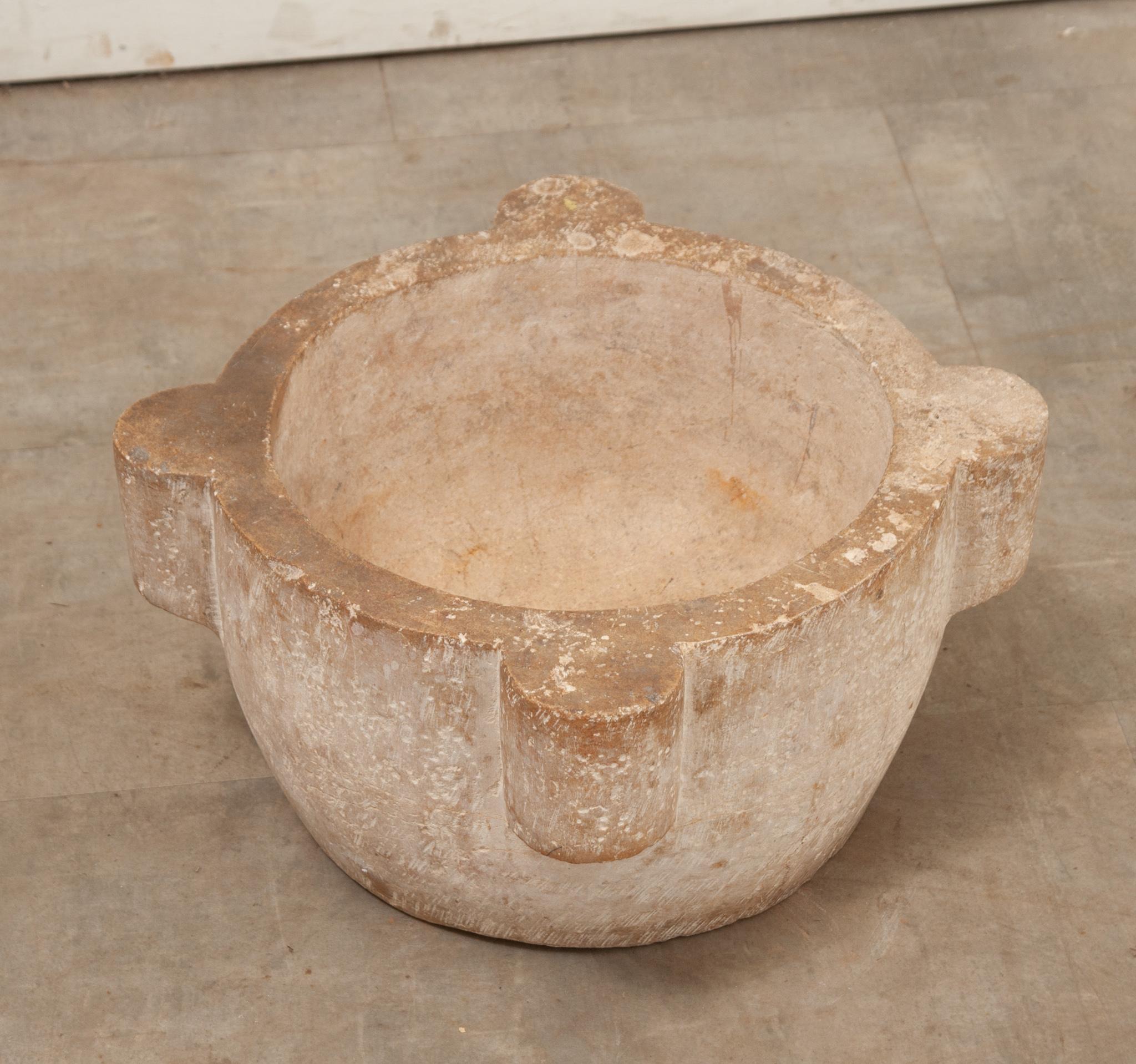 A French stone mortar used to grind herbs and spices. This mortar is hand-chiseled from one piece of stone and has four handles, making it easy to use and carry. Be sure to view the detailed images to see the current condition of this antique mortar.