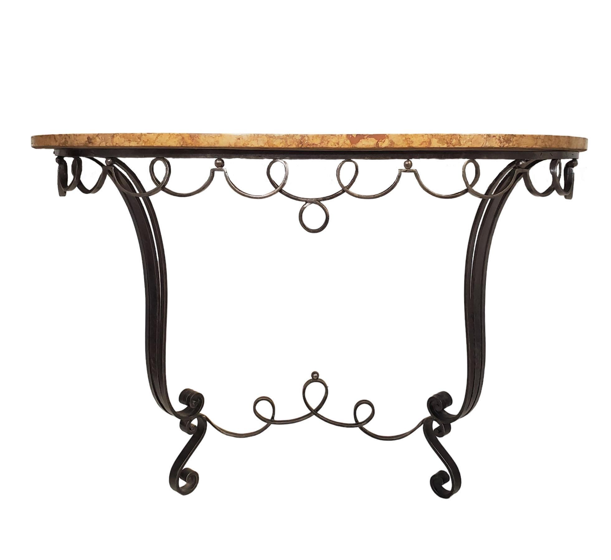 An original French Art Deco elegantly shaped demi-lune console. The base skillfully crafted from hand-forged iron features a lyrical, scrolling, curvilinear apron supporting its original and warmly toned breche marble top.
The color of the marble