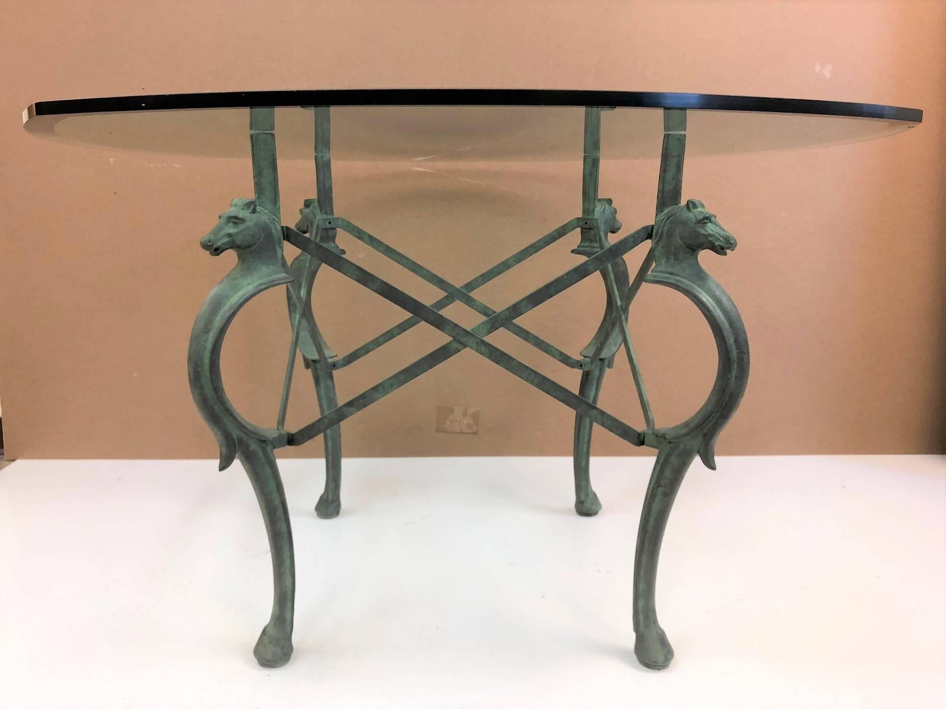 French style hand-forged patinated iron seahorse table. The table has a four-sided curved bevelled edge glass top. This table can be used for indoor or outdoor use.