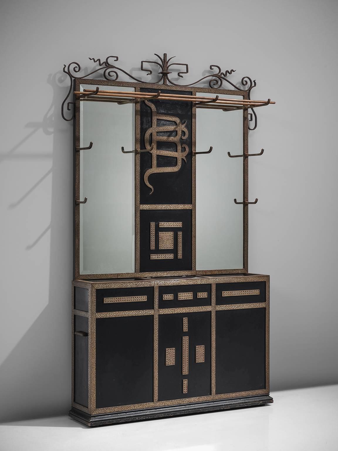 Console with mirror, black and patinated metal, mirror, wood, France, circa 1950.

This wall unit has a graphic, stylized bottom unit and a mirror with decorated metal panel in the middle. On top this cabinet holds a wooden hat rack. The middle