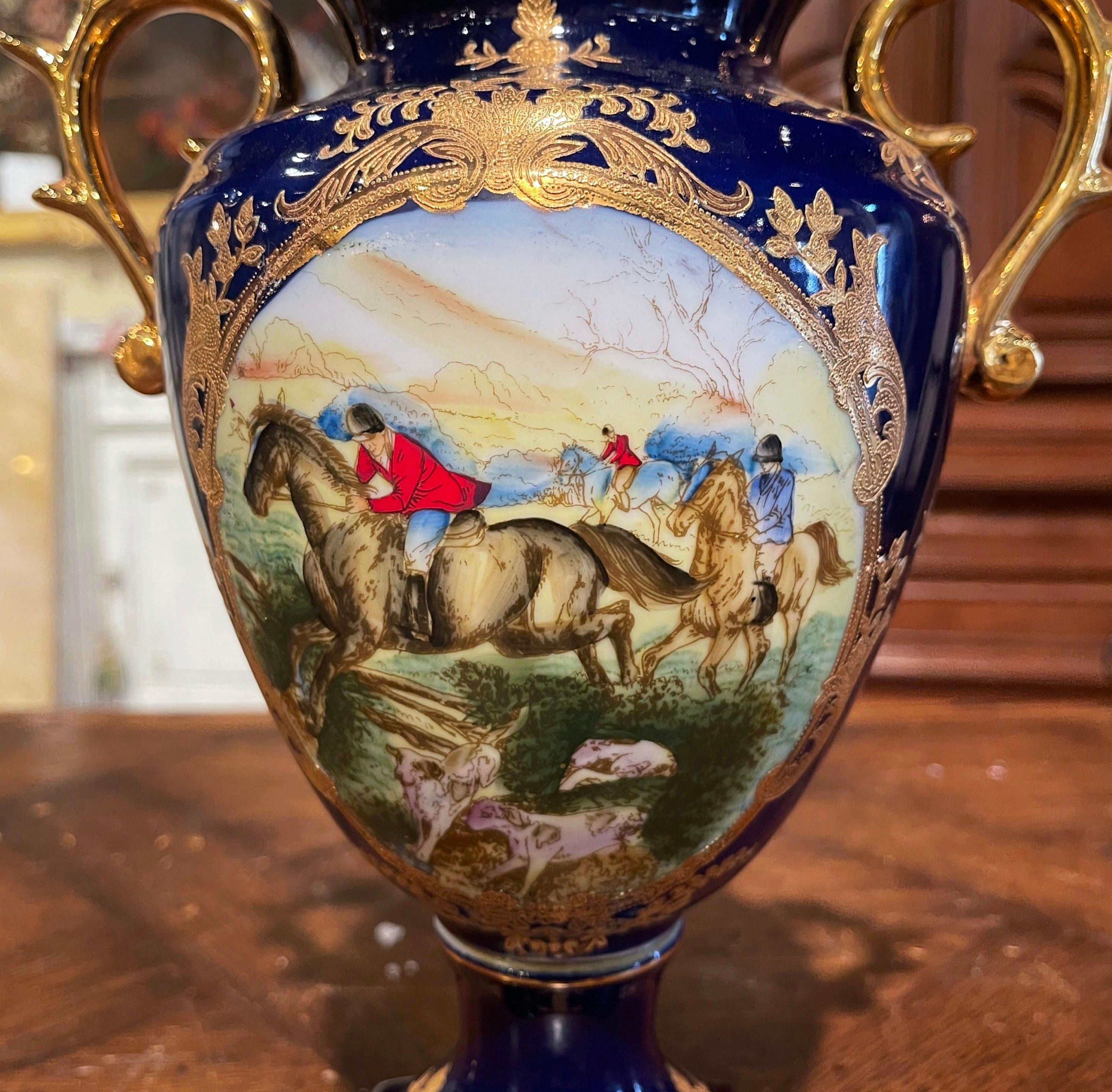 Decorate a mantel or a console with this elegant porcelain urn in the manner of Sevres. Created in France, circa 1980, the decorative vessel sits on a square base, and is dressed with two intricate handles over a removable lid with cone shaped