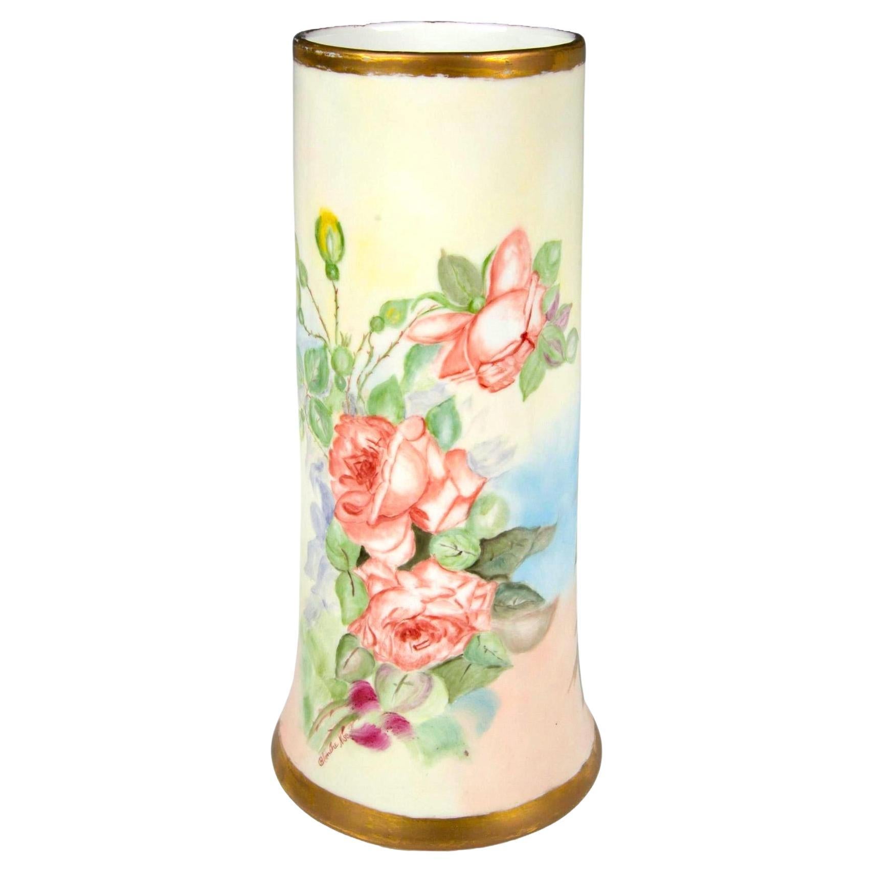 Introducing a magnificent antique porcelain vase from Limoges, France, crafted by D&C and hand-painted with intricate floral designs. This large vase showcases a lush arrangement of hand-painted roses, highlighted by delicate gilded trims that add a