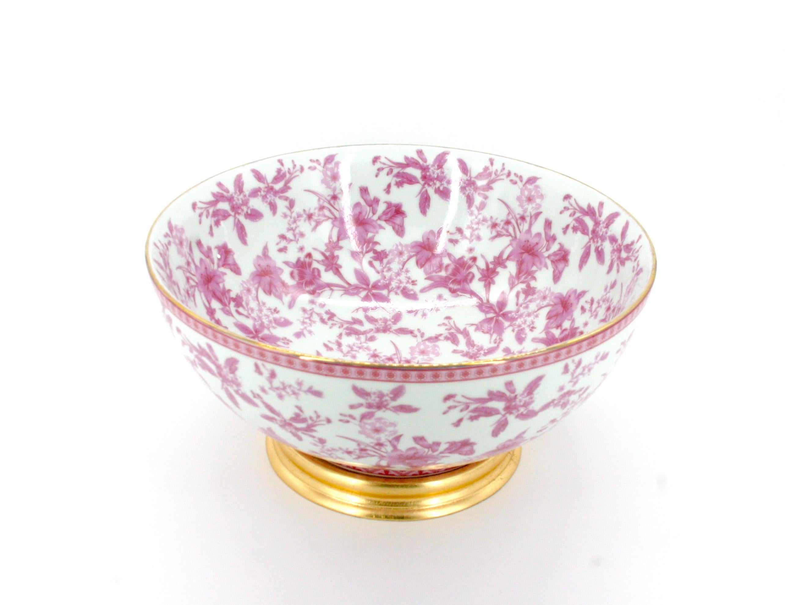 Magnifique bol décoratif / bol à punch en porcelaine émaillée française peint à la main. Le bol présente des détails floraux à l'intérieur et à l'extérieur, avec une garniture dorée sur le dessus et une base en bois doré détachable. Le bol est en